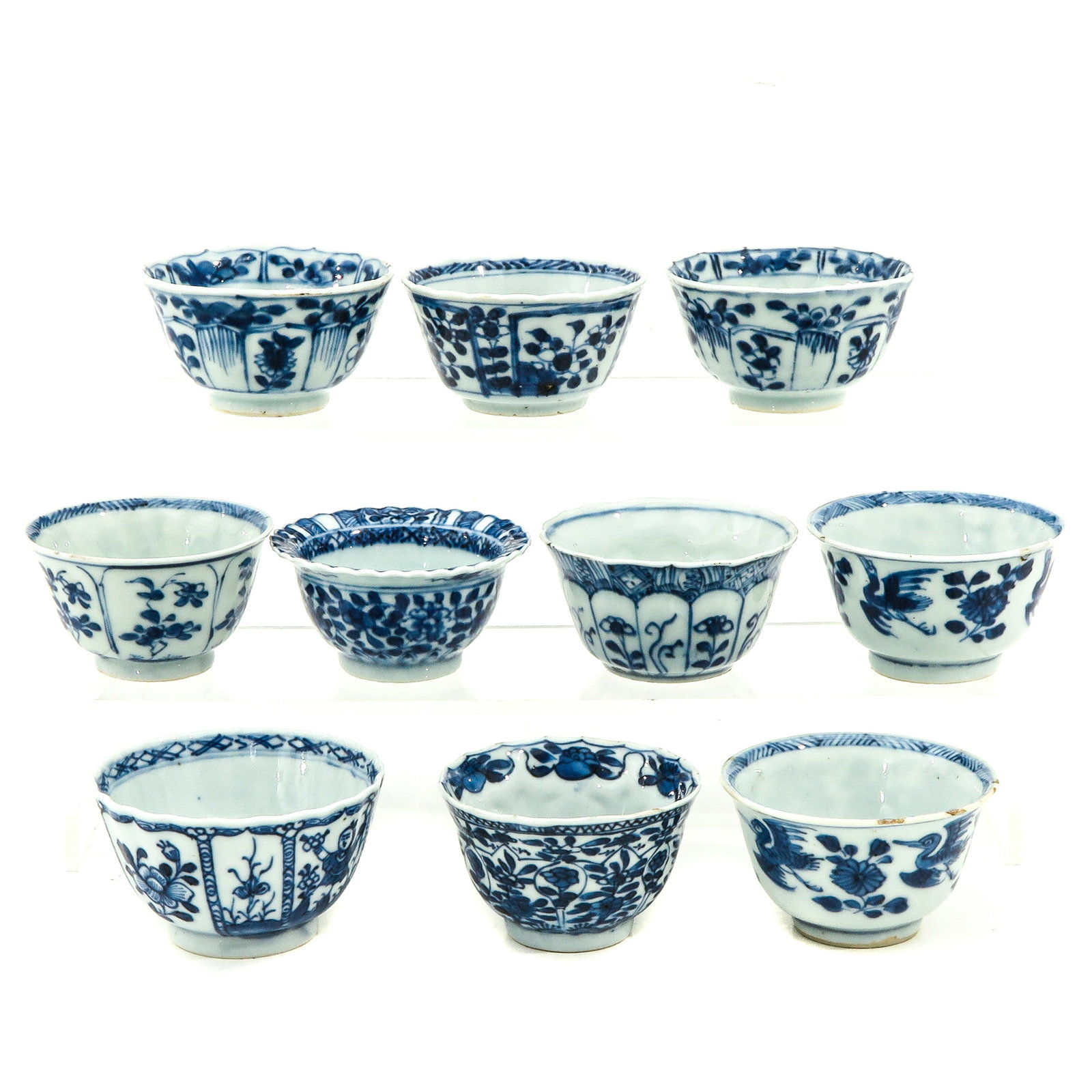 A Collection of 10 Blue and White Cups: Floral decors, including 18th Century, largest cup is 7 cm. in diameter, chip and hairline.