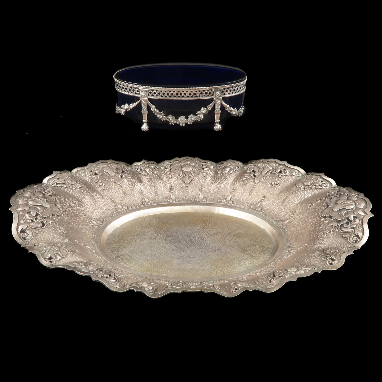 A Group of Silver: consisting of large Djokja silver bowl and a silver jardiniére decorated with garlands and blue glass inner bowl, length 44 cm.