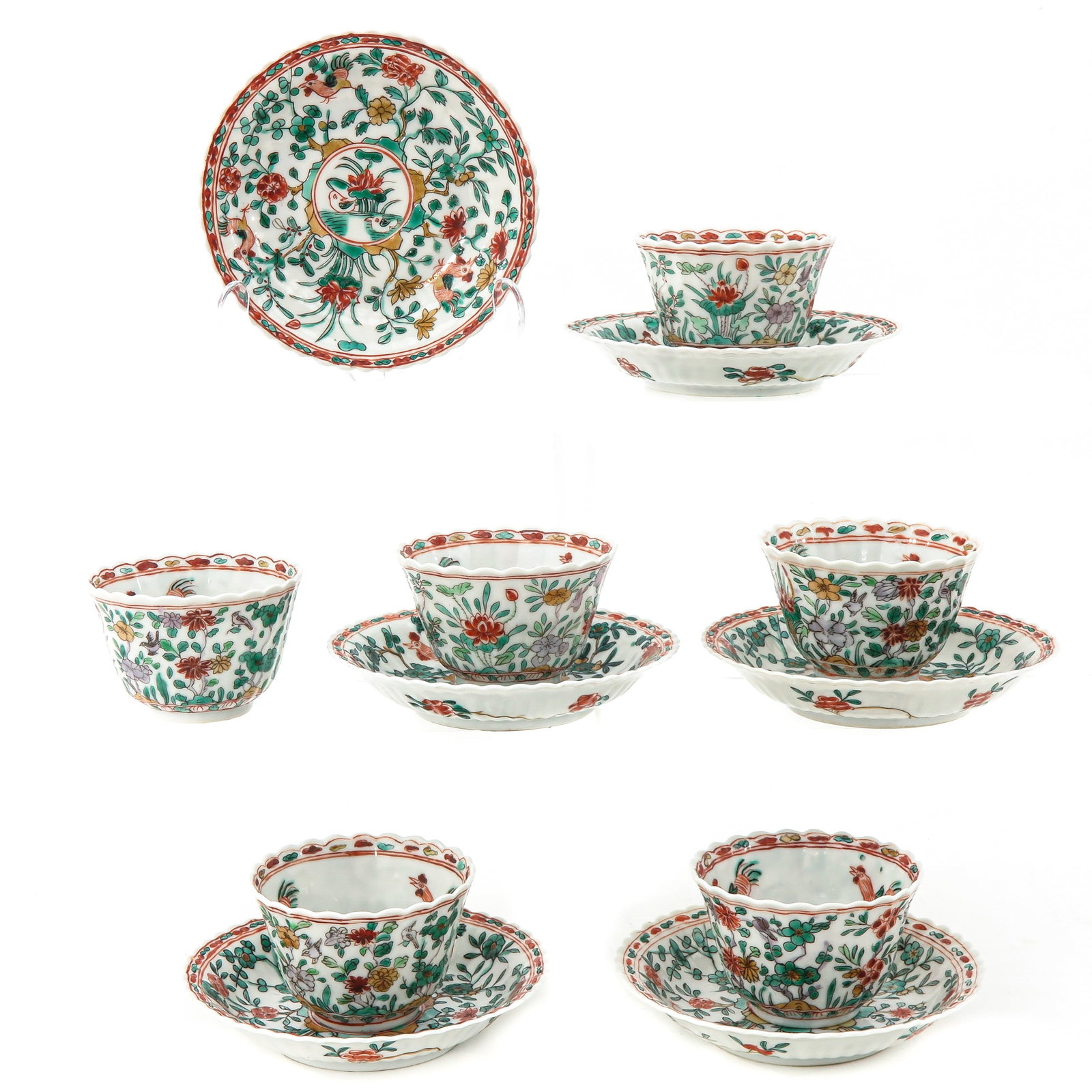 A Set of 6 Lobed Famille Verte Cups and Saucers: Decorated with roosters among flowers, Kangxi Mark and Period, saucers are 13 cm. in diameter, one cup is restored.