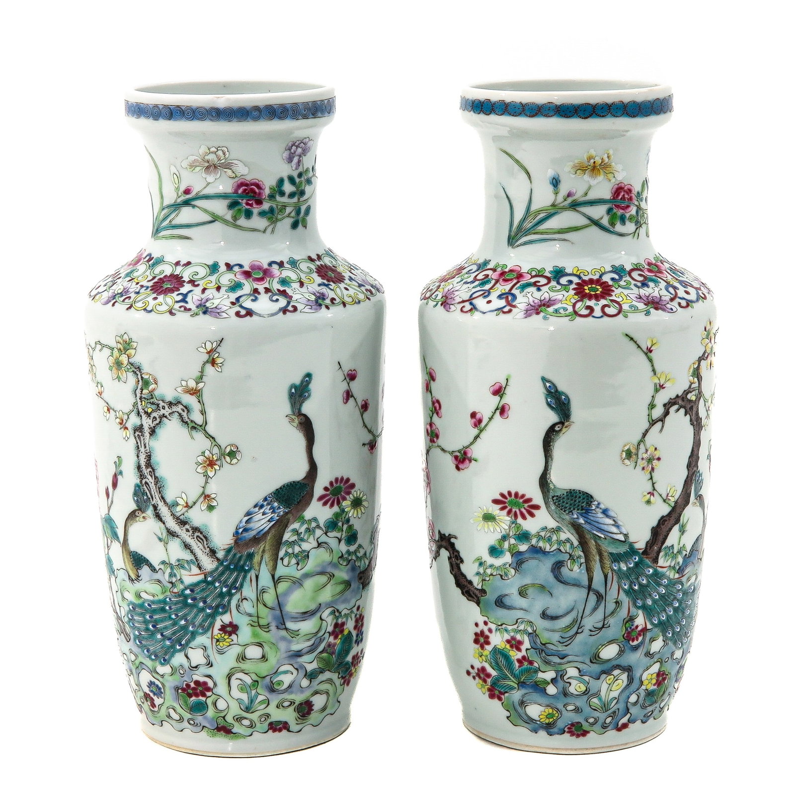 A Pair of Famille Rose Vases: Depicting peacocks in a graden with flower blossoms, 25 cm. tall, chip.