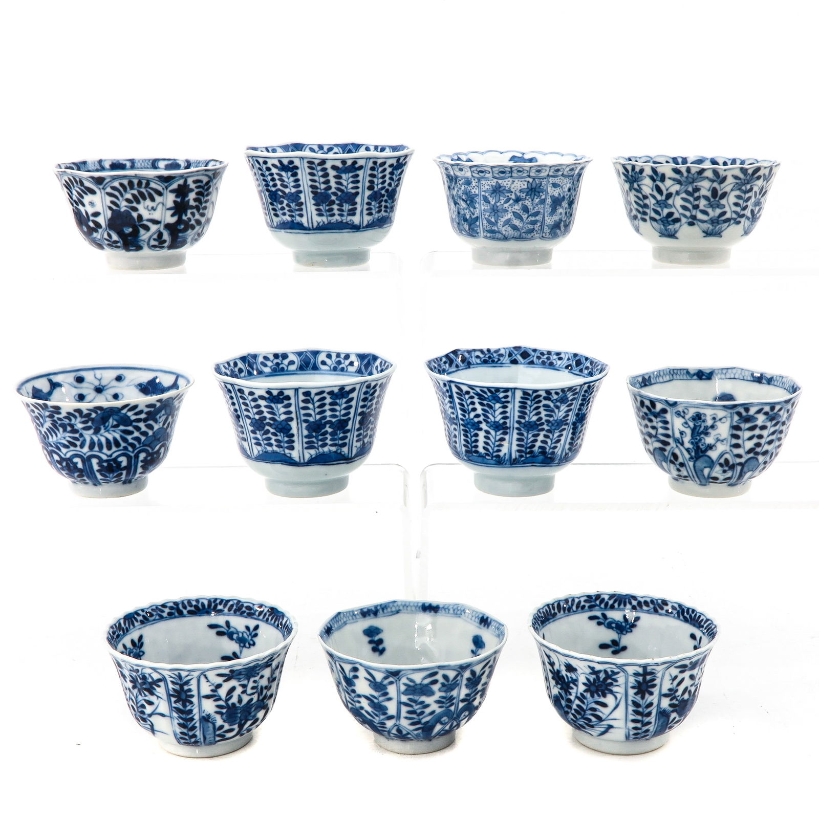 A Collection of 11 Cups: In a variety of blue and white decors, largest cup is 9 cm. in diameter, chip.