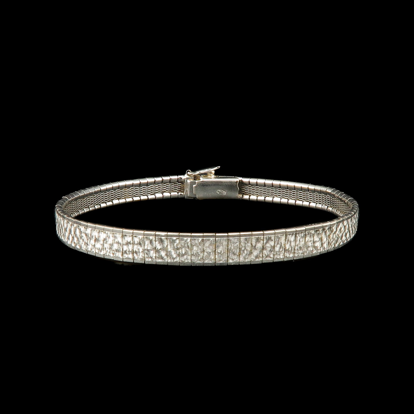 An 18KG Bracelet: with engraved decorative pattern, length 19 cm.