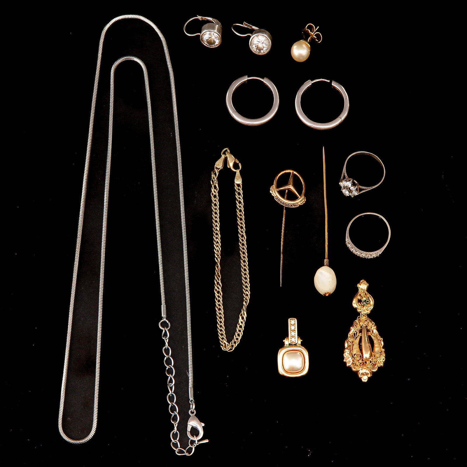 A Group of Jewelry: Various jewelry, including necklaces, earrings, and tie pins, in silver and gold.