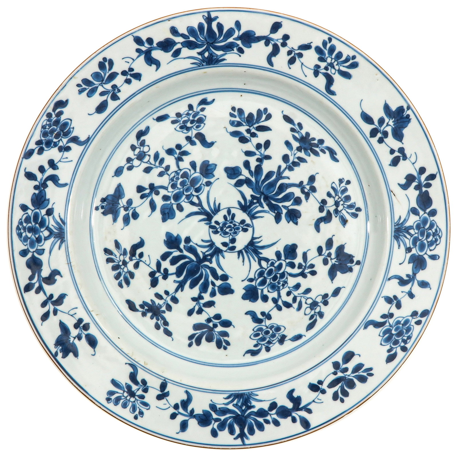 A Large Blue and White Charger: Decorated with coninuous floral design in underglaze cobalt blue, with wide rim and brown edge border, 18th Century, chip on stand ring.