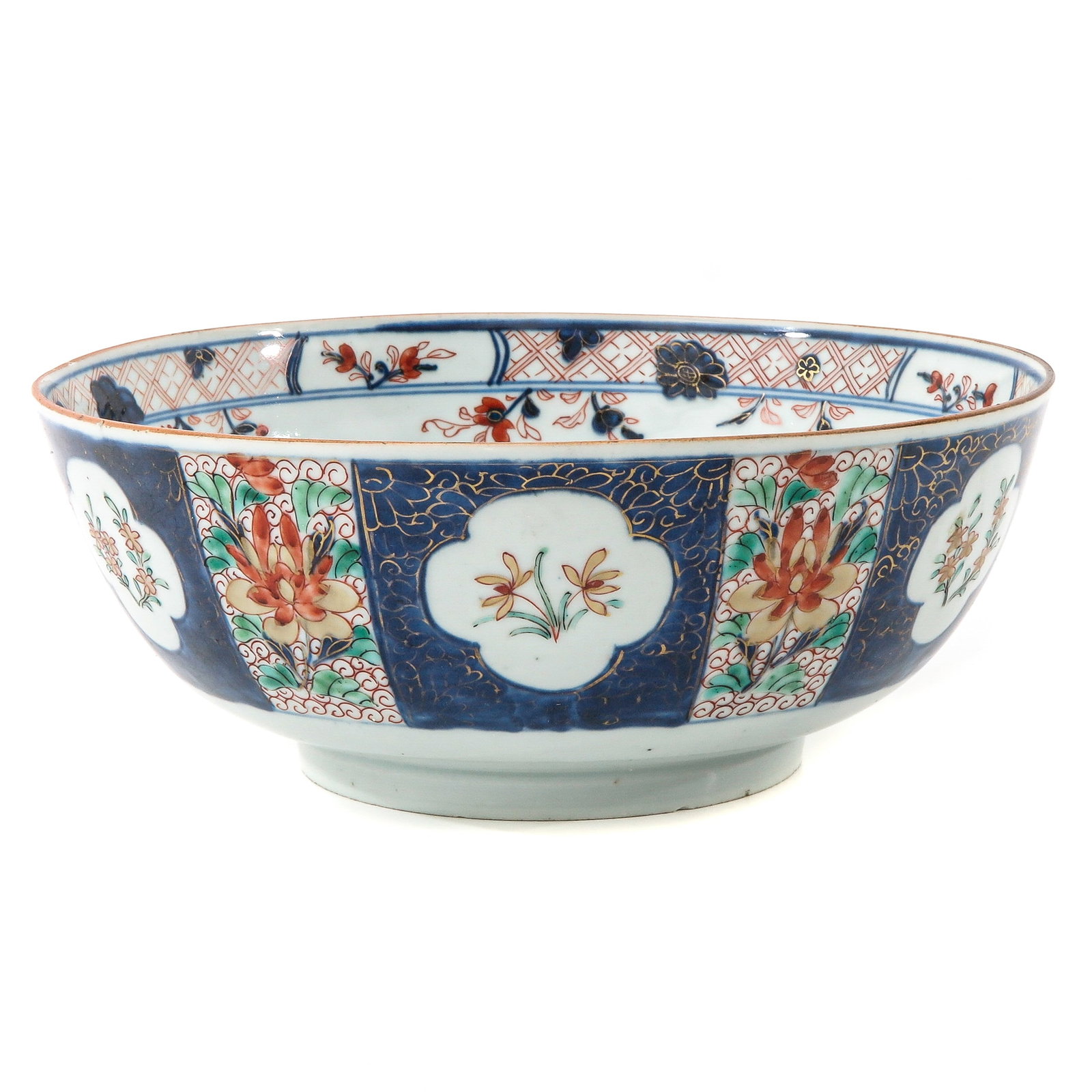 An Imari Serving Bowl: On raised circular base, blue ground decorated with panels of flowers in iron red and gilt enamels, 18th Century, 27 cm. in diameter,