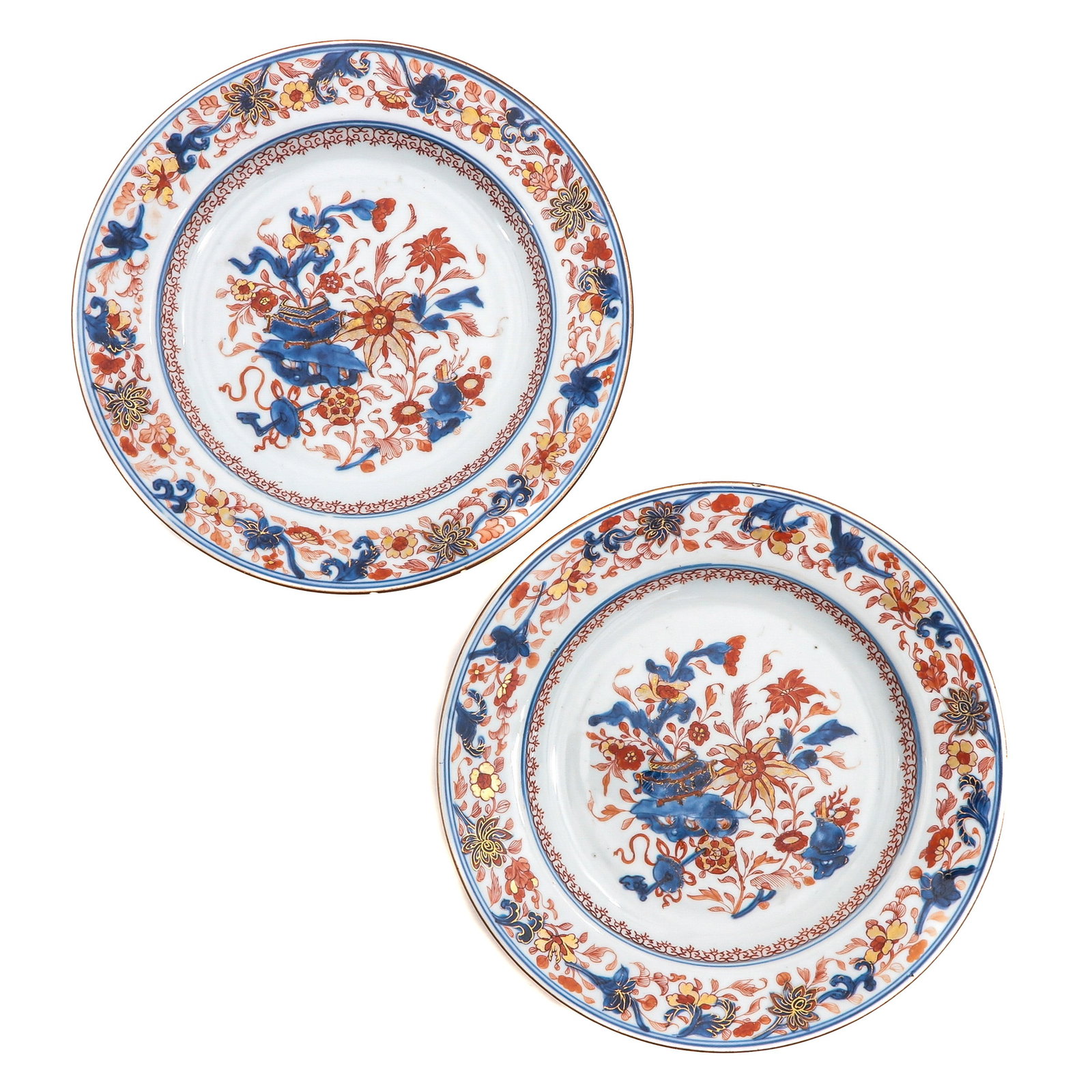 A Pair of Imari Plates: Depicting flowers and Chinese antiquities, 18th Century, 25 cm. in diameter, chip and hairline.