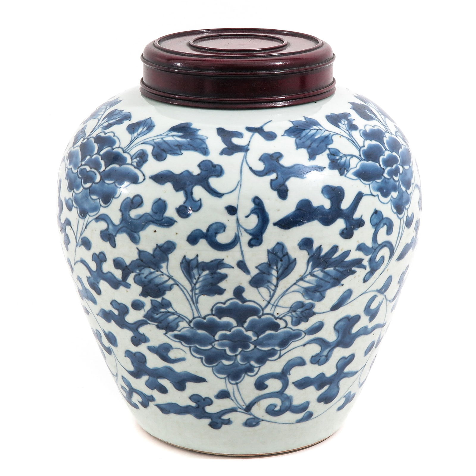 A Blue and White Ginger Jar: Scrolling flowering decor, Transitional Period, with wooden cover, 25 cm. tall.