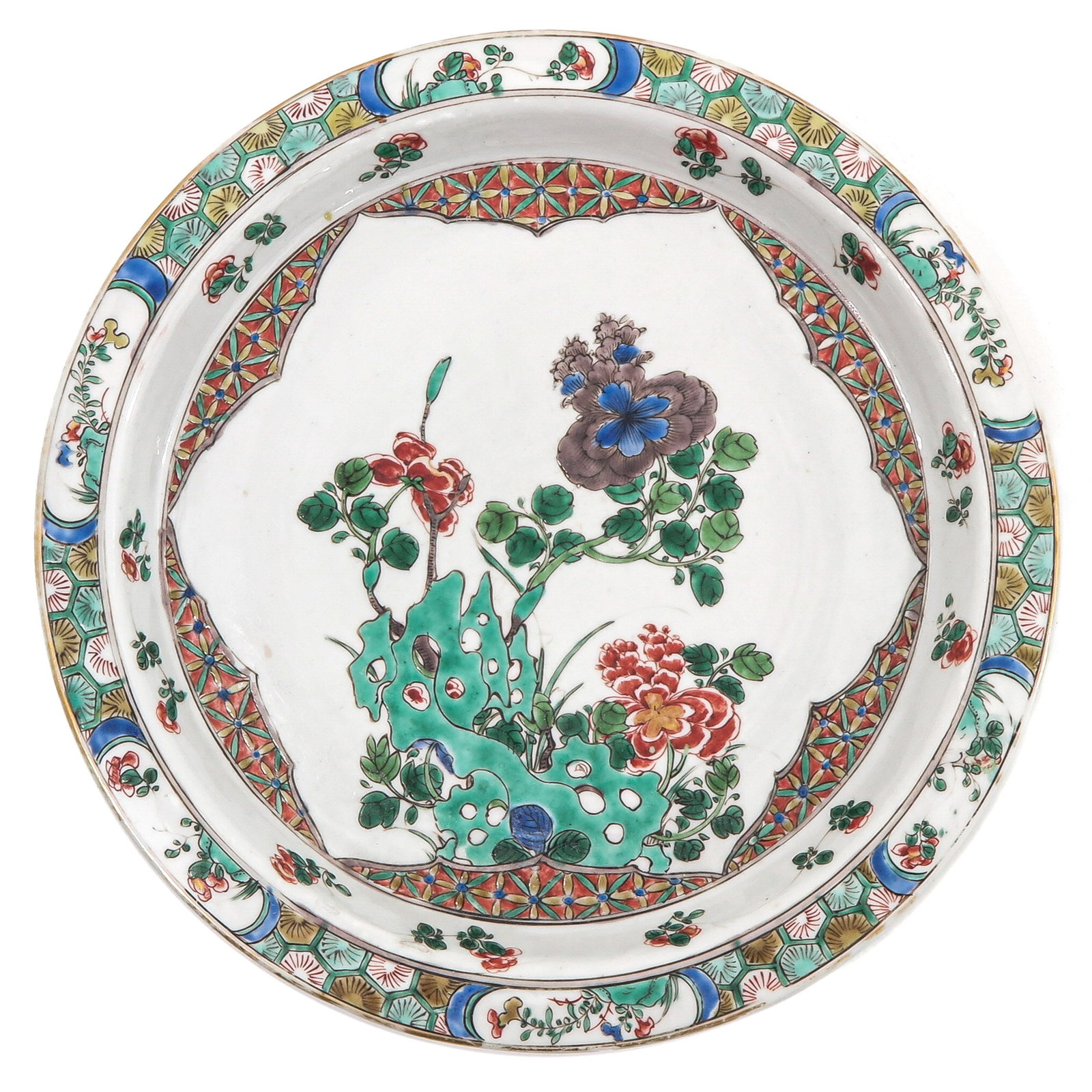 A Famille Verte Plate: Depicting a scene in a garden with flowers, and rocks, Kangxi Period, 28 cm. in diameter, chip.