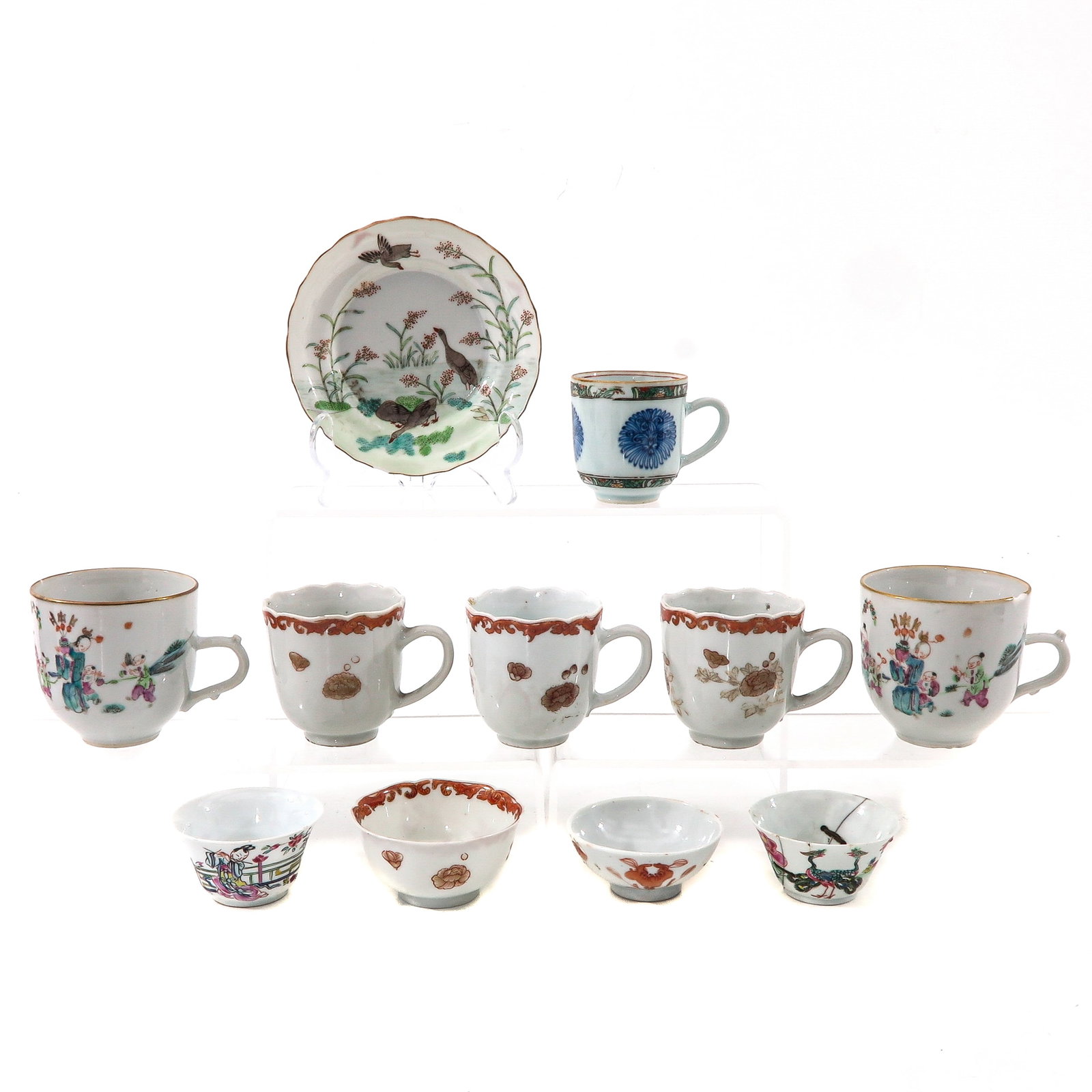 A Group of Porcelain: 11 pieces, including 10 cups and 1 saucer, 12 cm. in diameter, in diverse conditions.