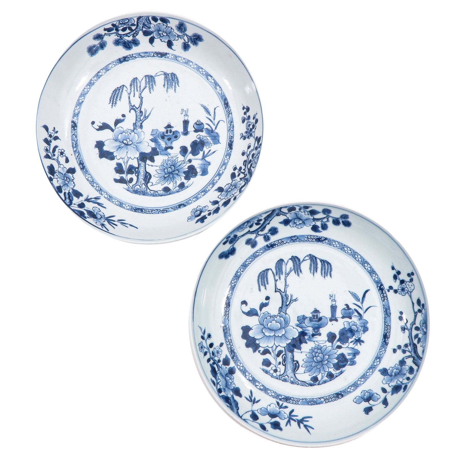 A Pair of Blue and White Plates: Depicting a scene in a garden with Chinese antiquities, 29 cm. in diamter, chip.