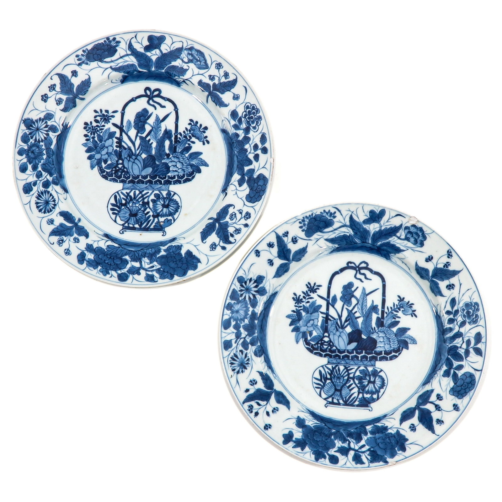 A Pair of Blue and White Plates: Depicting a basket with flowers in the center of the plate surrounded by panels of flowers, 18th Century, 28 cm. in diameter, chip.