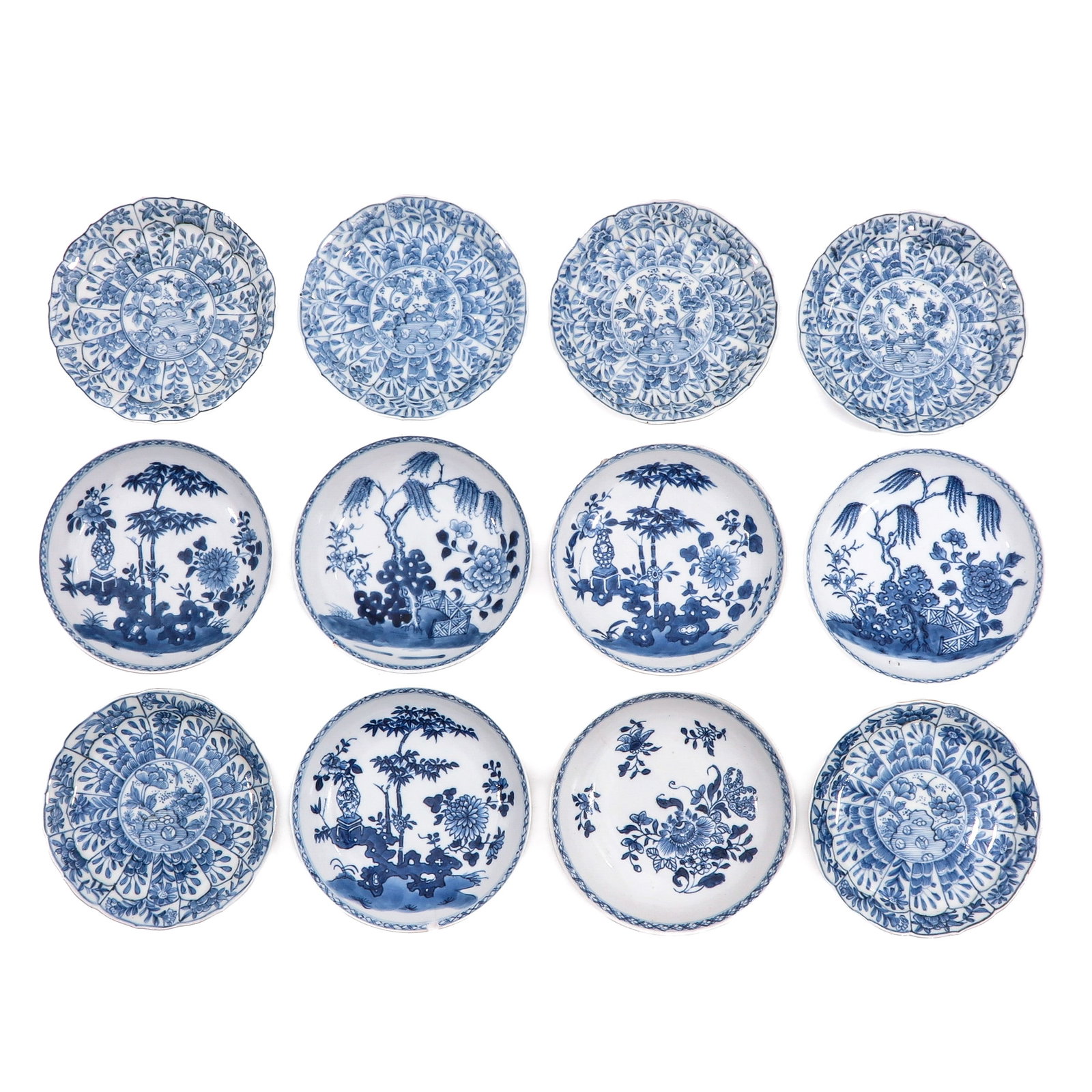 A Group of 12 Blue and White Small Plates: Including flowers decors and scenes in a garden, largest plates are 14 cm. in diameter, chip and hairline.