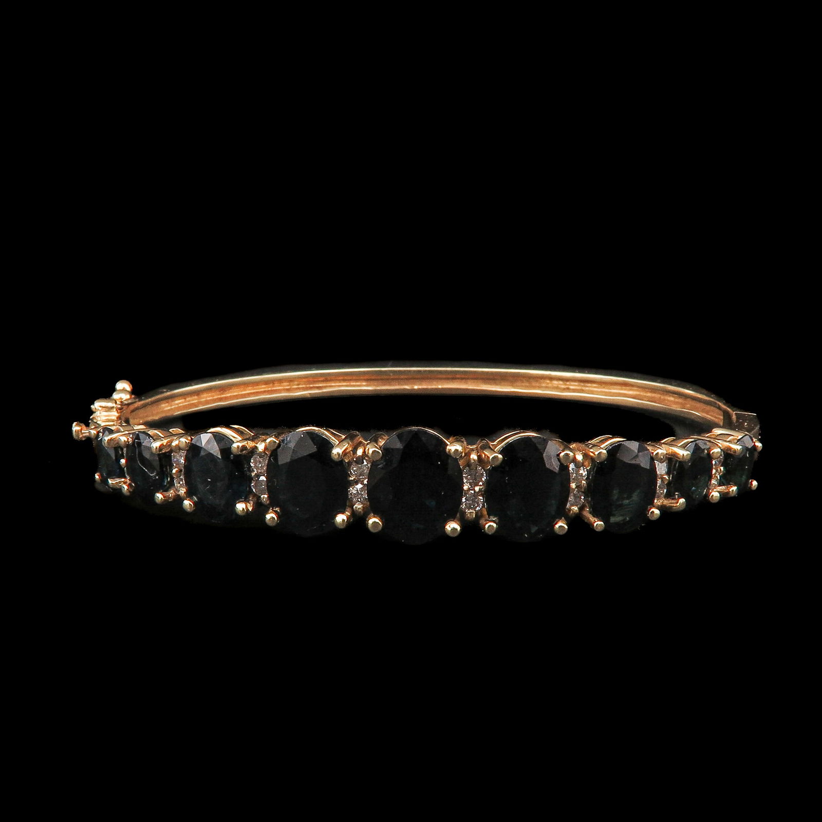 A Sapphire and Diamond Bracelet: Gold, set with nine oval-cut sapphires and diamonds, the largest sapphire 8 x 10 mm.