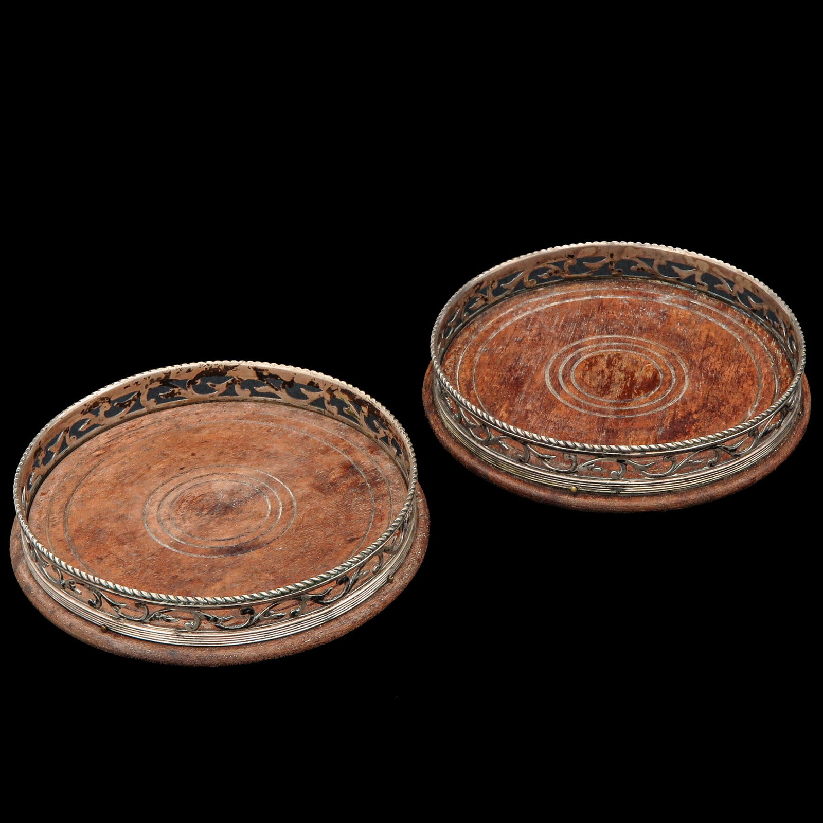 A Pair of Coasters: Bottle holders with silver rims, diameter 12 cm.