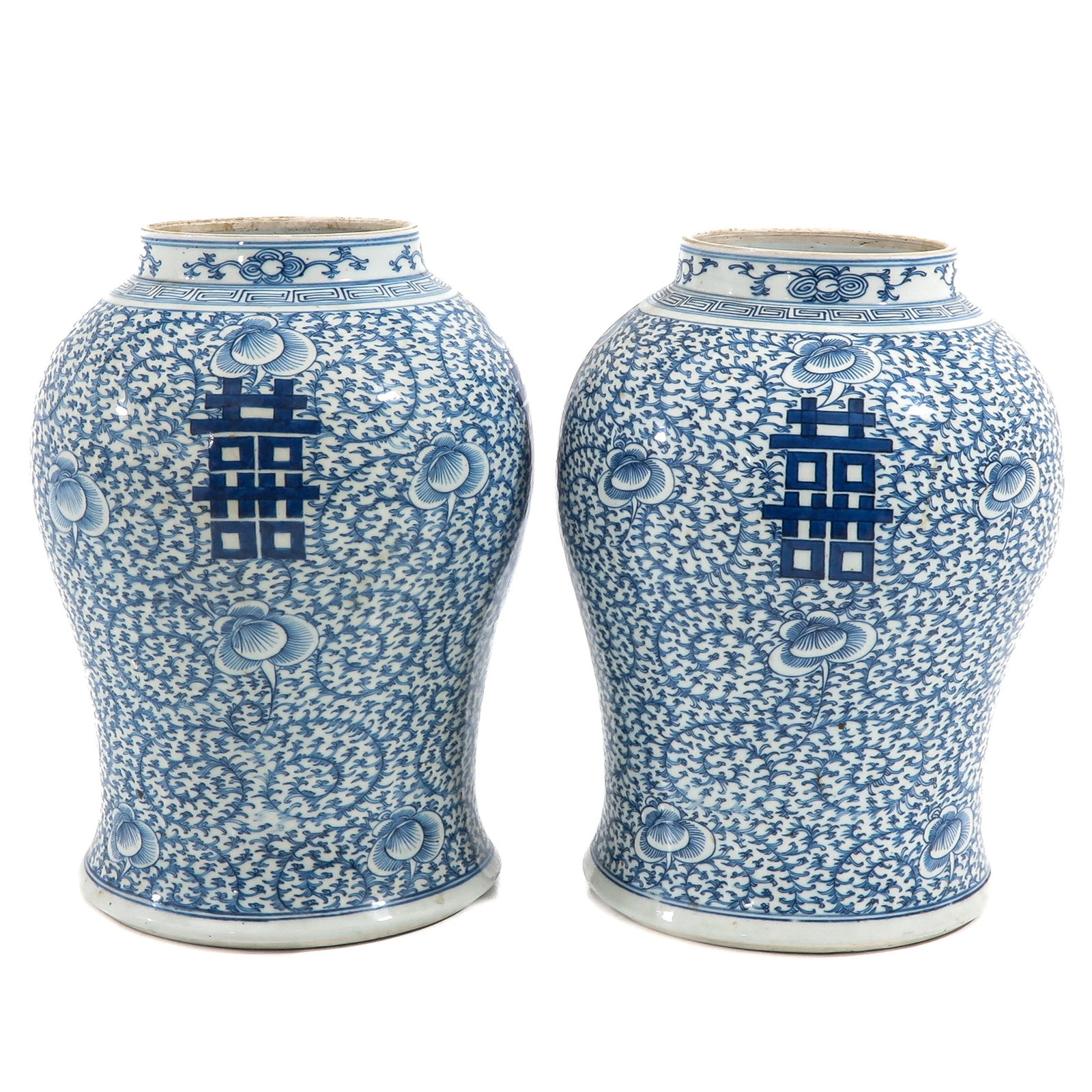 A Pair of Blue and White Ginger Jars: Floral ground with Chinese symbols, 19th Century, 36 cm. tall, in diverse conditions.