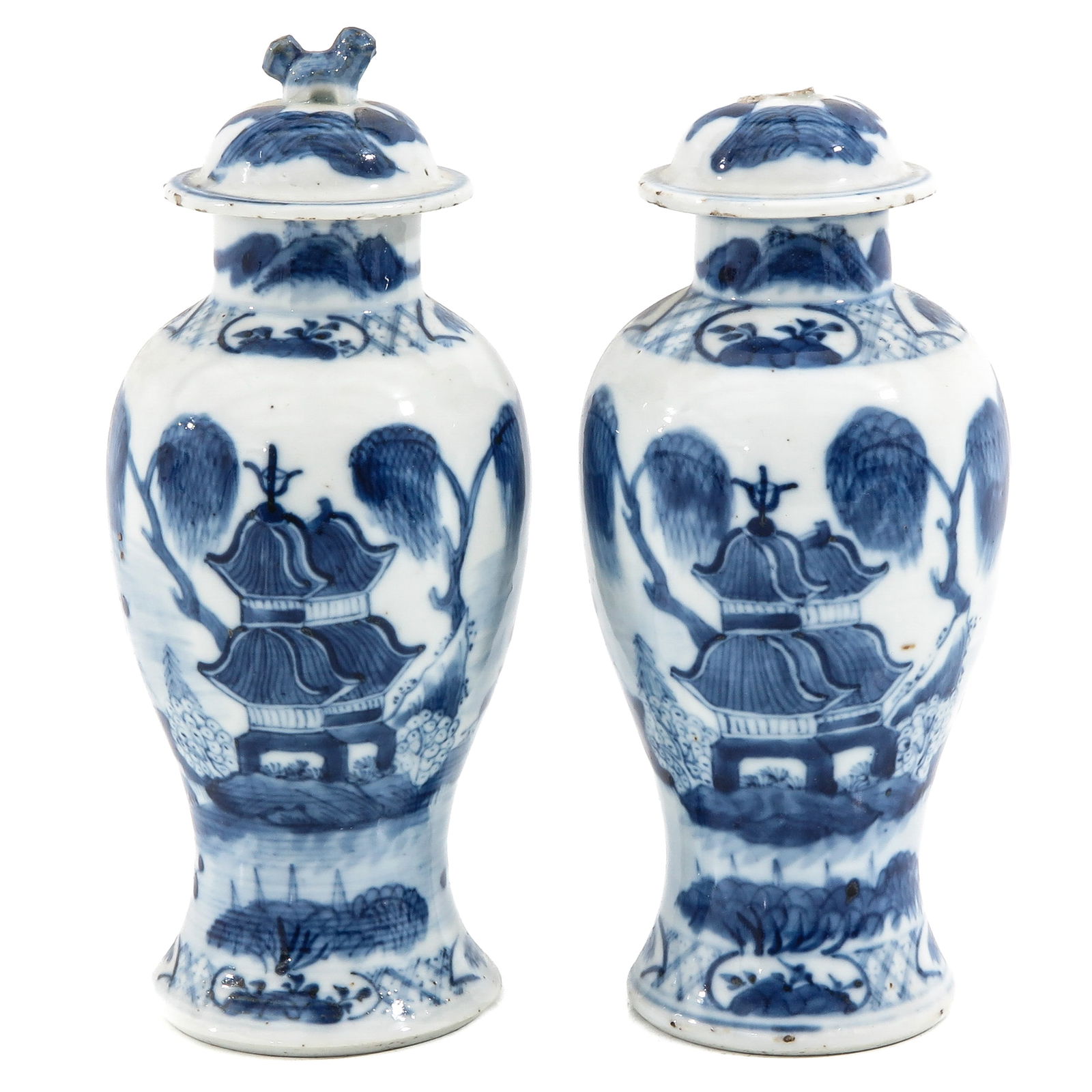 A Pair of Blue and White Vases with Covers: Landscape decor, 19th century, 22 cm. tall, on tip missing on cover.