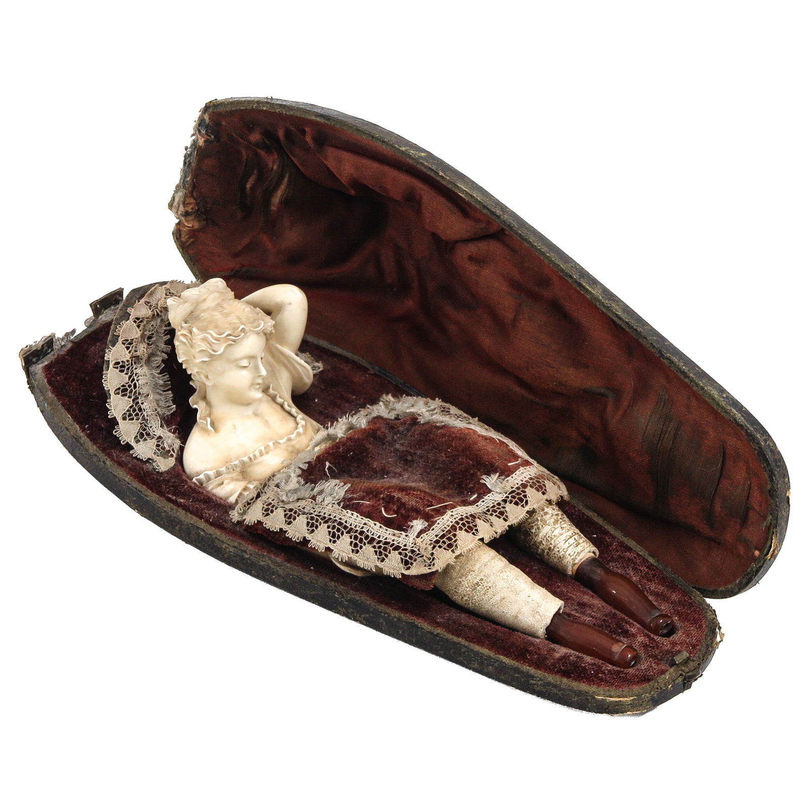 A Rare Meershaum Pipe: Rare, in the form of a woman reclining in a bed-shaped diorama case, her legs forming two cheroot holders, a total of three pipes, length 16 cm.