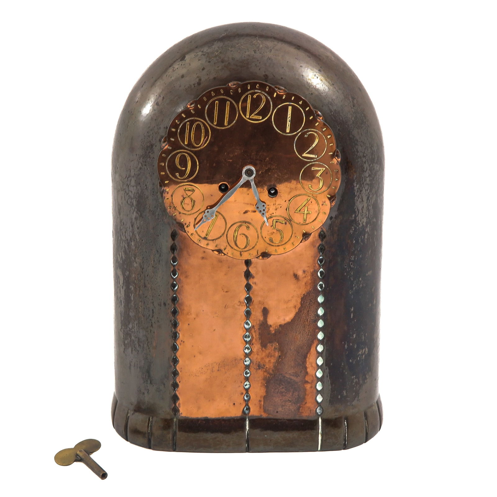 A Table Clock: Amsterdam School, copper case, dial with stylized Arabic numerals and original key, height 34 cm.