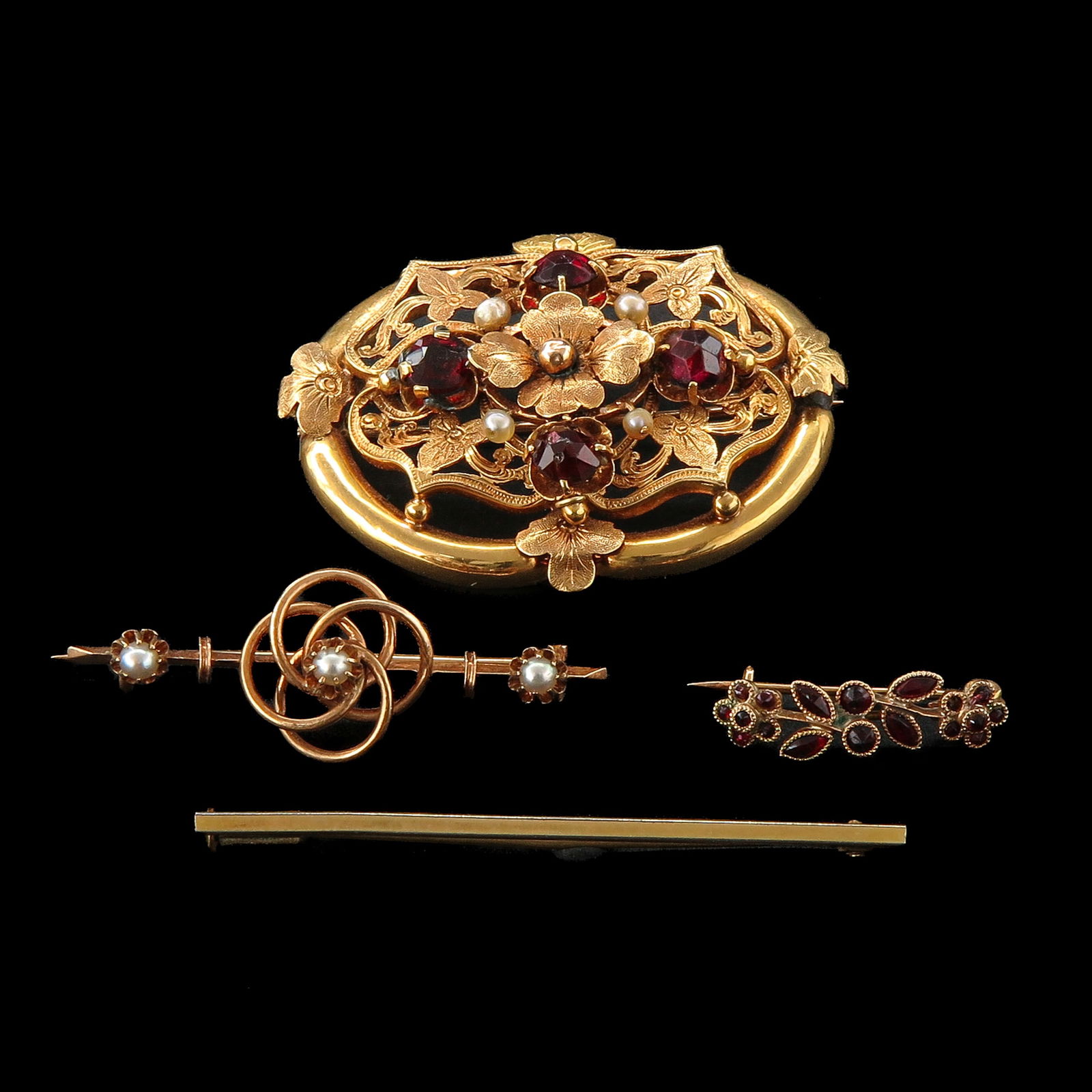 A Group of 4 Brooches: Consisting of 4 brooches, including gold and garnets, longest 42 mm.