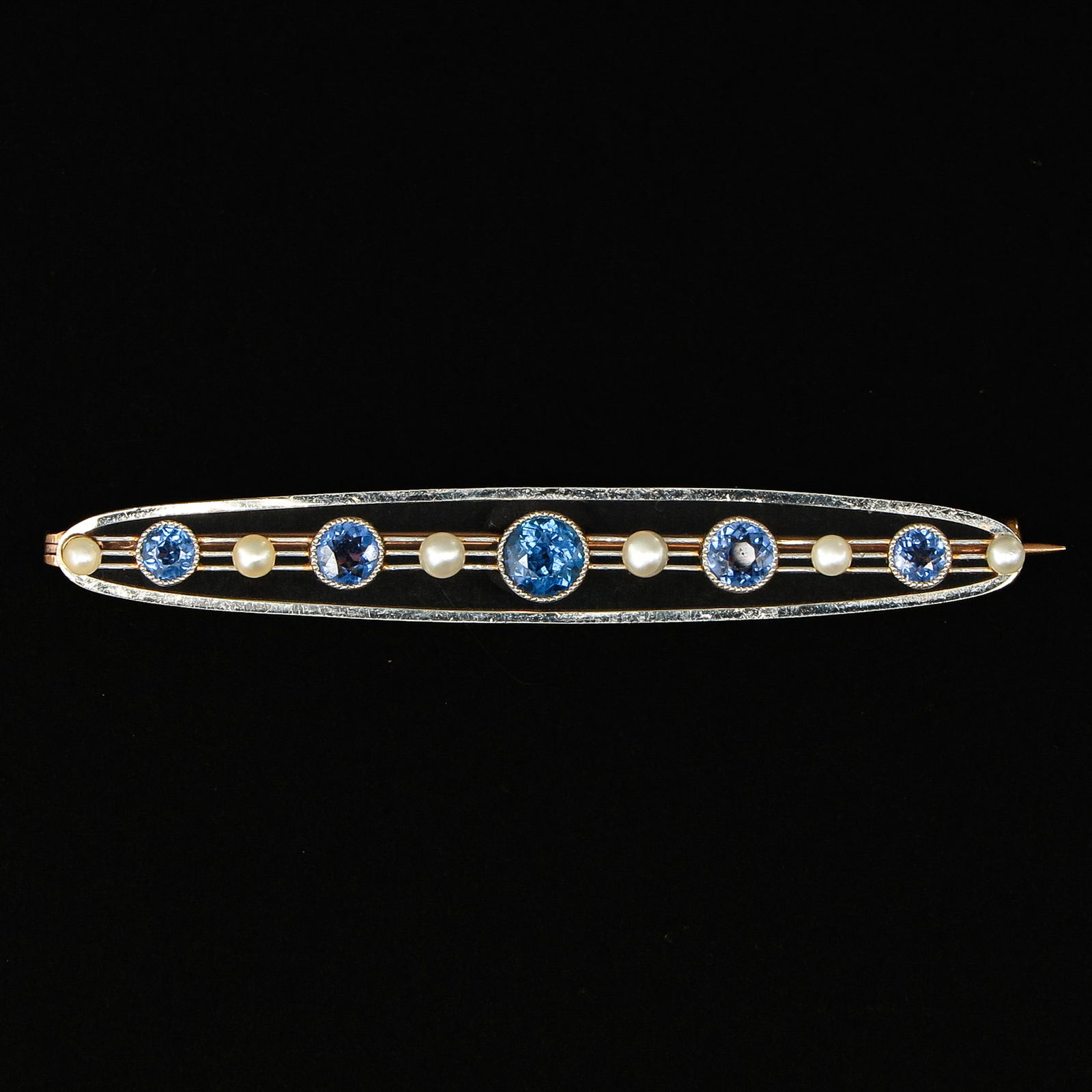 A Bar Pin Set with Sapphires and Pearls: Set with 5 sapphires and 6 seed pearls, length 15.5 cm.