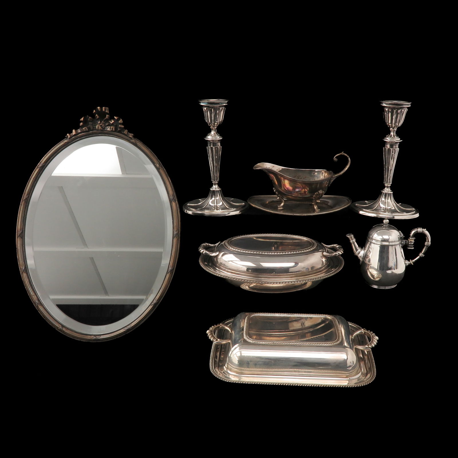 A Diverse Collection of Items: Consisting of candlesticks, serving dishes, a teapot, and an oval mirror, including Christofle Paris, tallest 46 cm