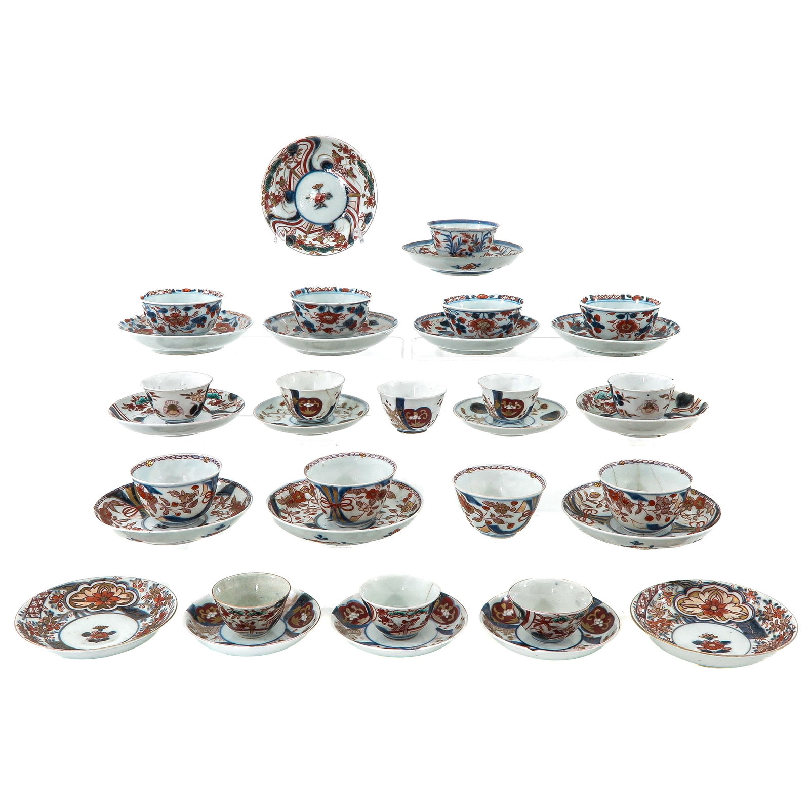 A Large Group of Imari Cups and Saucers: Iron red and blue floral decors, saucers are 13 cm. in diameter, 18th Century, in diverse conditions.