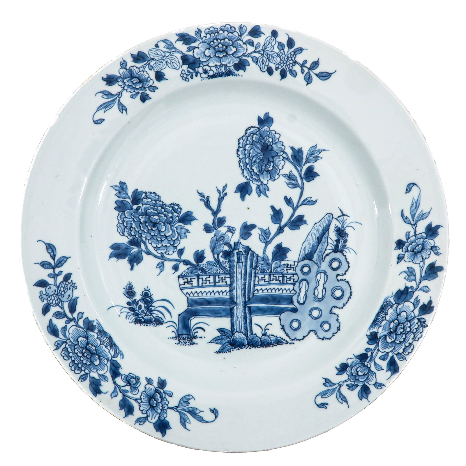 A Blue and White Charger: Decorated with peonies and antiquities within a floral border, 18th Century, 39 cm. in diameter, chip and hairline.