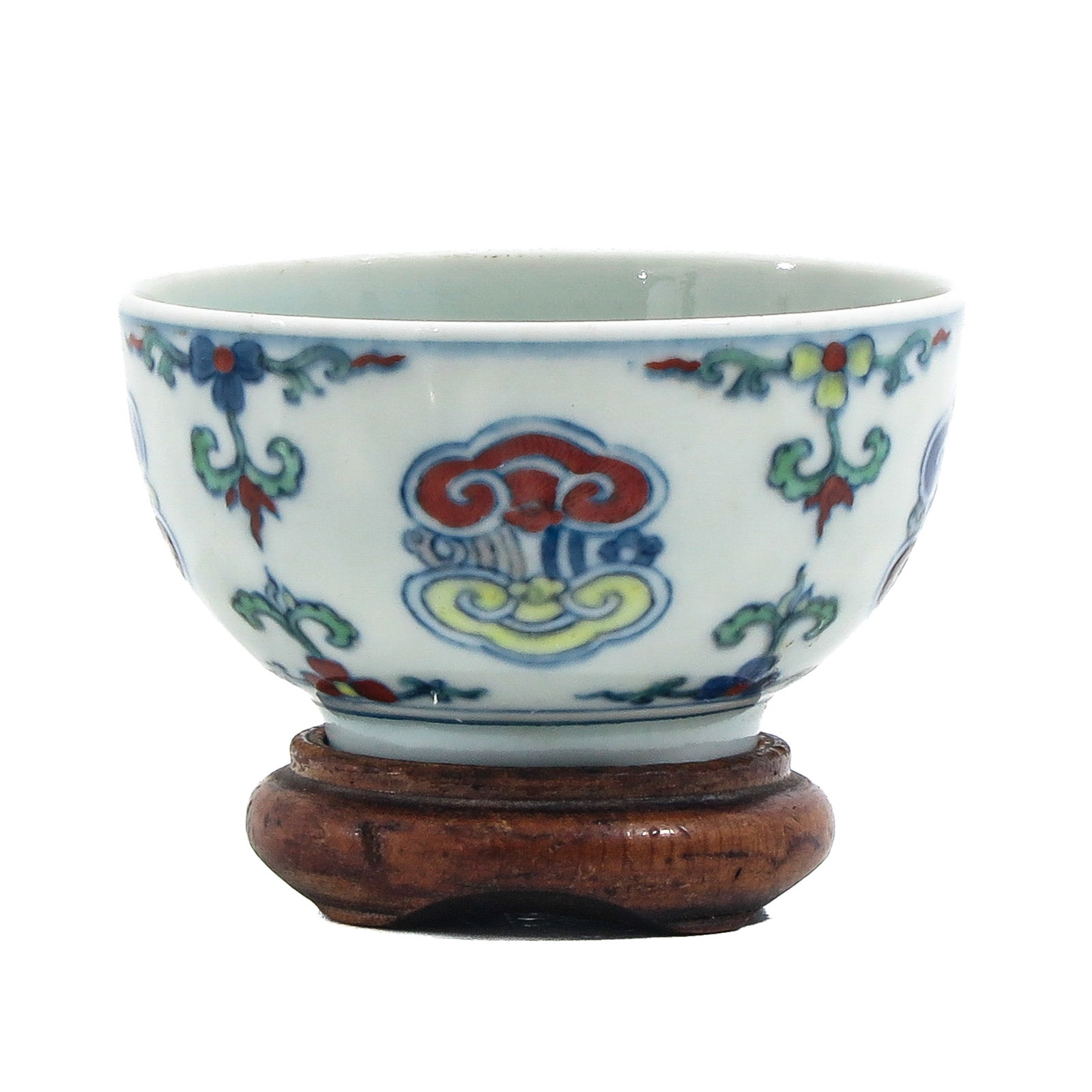 A Ducai Cup: Floral decor, 7 cm. in diameter, with a wood base.