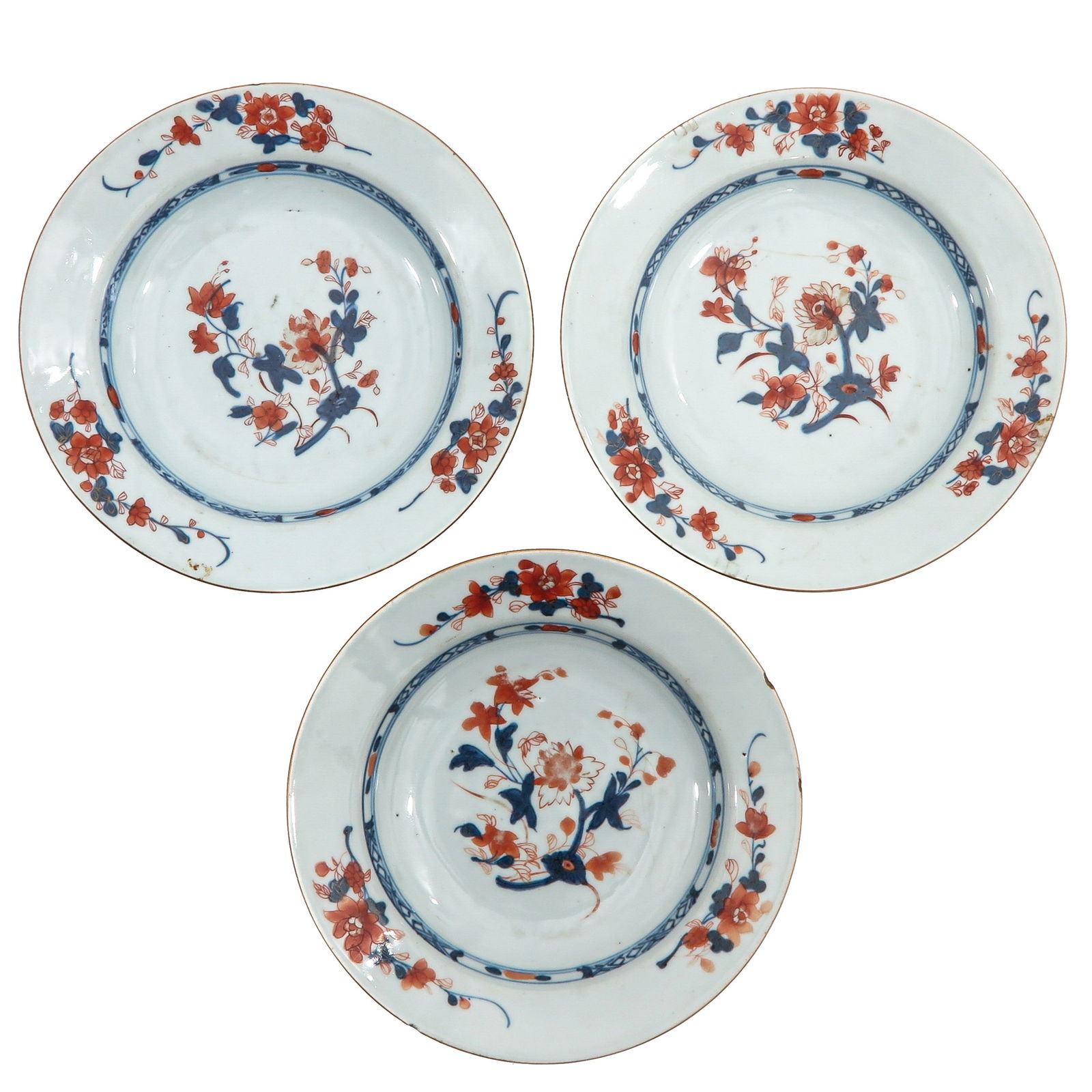 A Series of 3 Imari Plates: Decorated with floral sprays in underglaze blue and iron-red, 18th Century, 23 cm. in diameter, chip and hairline.
