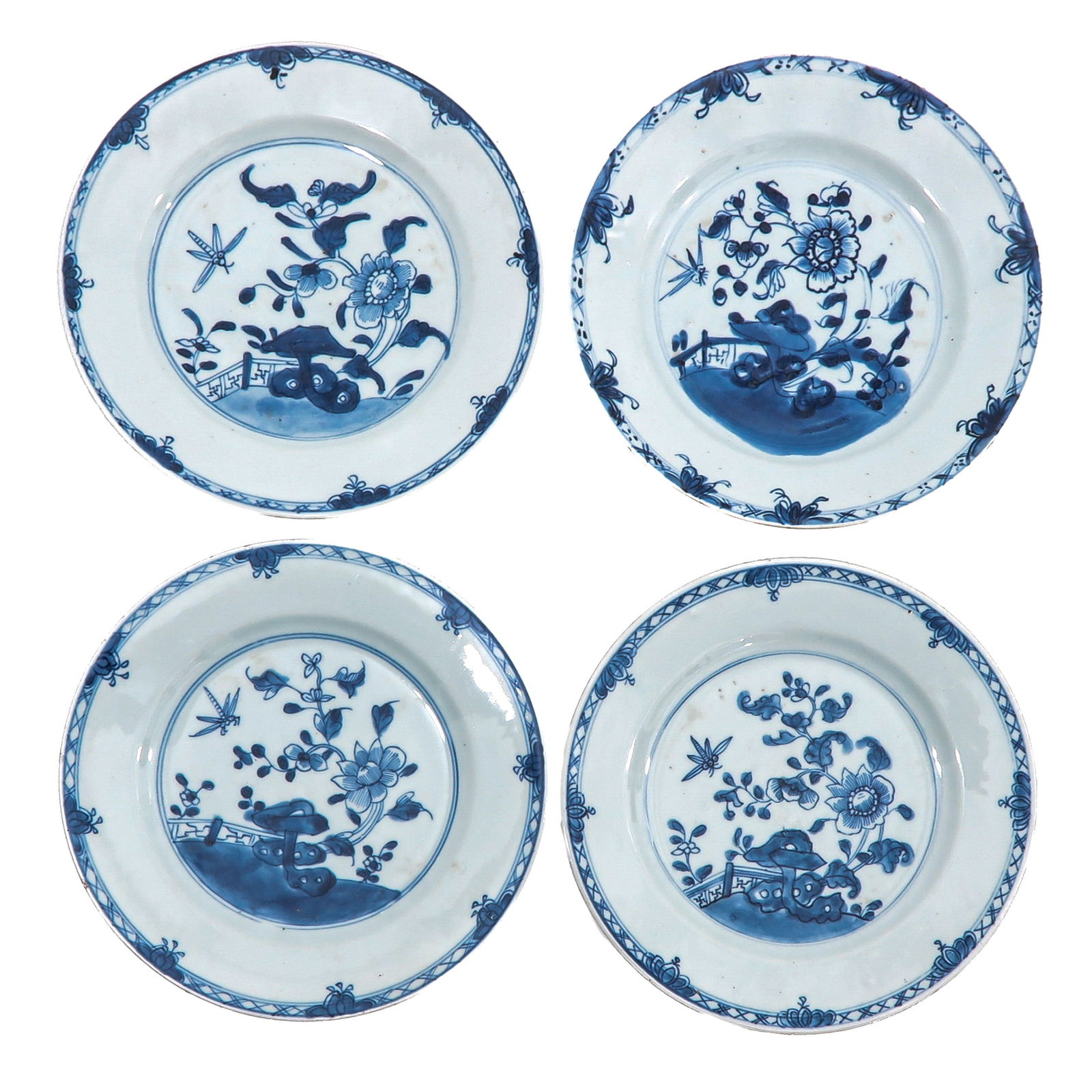 A Group of 4 Blue and White Plates: Each decorated with flowering plants, rockwork, and insects, 18th Century, 24 cm. in diameter, chip.