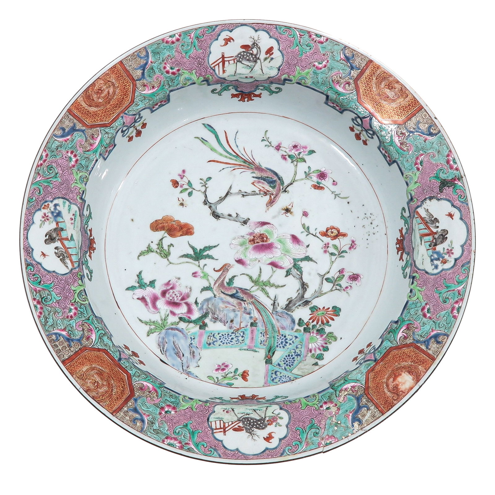 A Famille Rose Charger: The center decorated with a a peacock perched among flowering branches and rockwork, 18th Century, 40 cm. in diameter, restored.