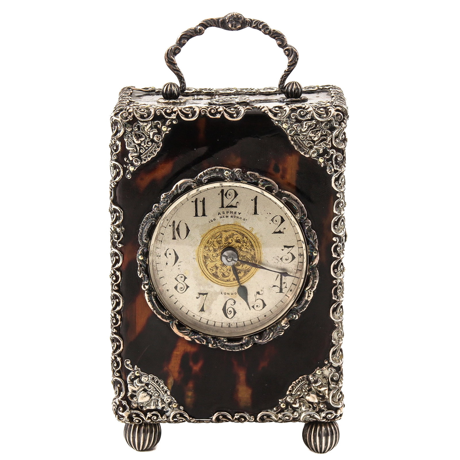 A Travel Clock with Alarm: richly decorated with silver, signed Asprey, London, provided with owner's monogram, height incl. handle 14 cm