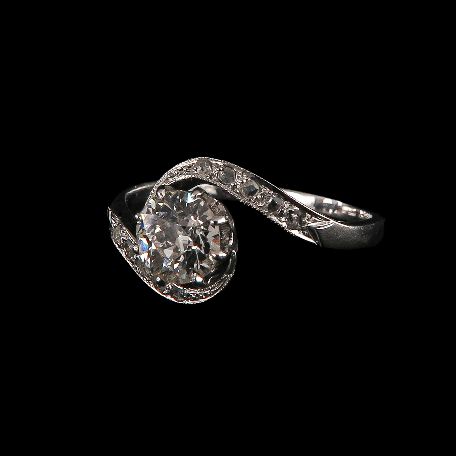 A 14KG Diamond Ring: 14 Krt. gold, set with a central diamond (approx. 6 mm) and small diamonds, ring size 18