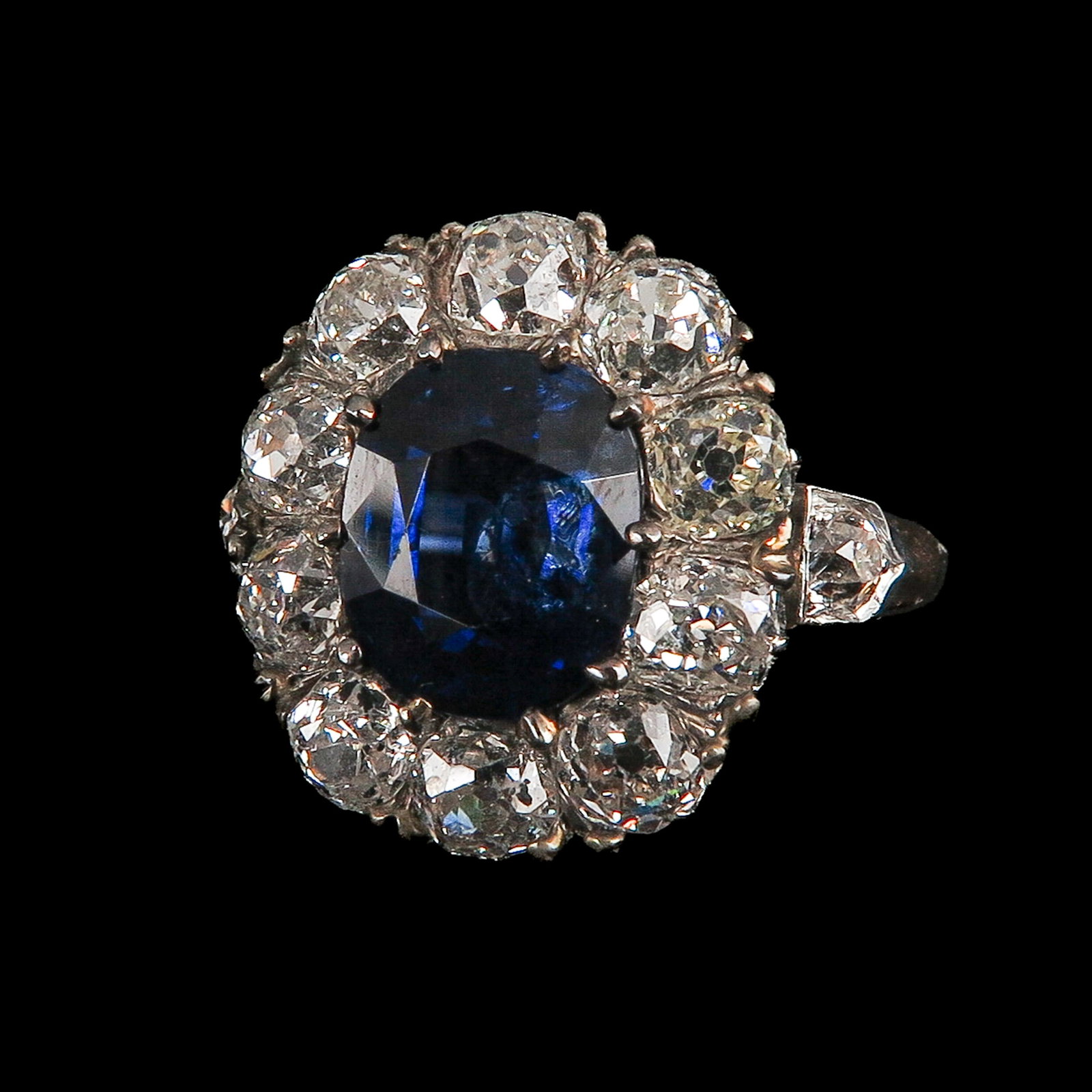 A Ladies 14KG Diamond and Sapphire Ring: 14 kt. gold with silver setting, set with an oval-cut sapphire, surrounded by 10 diamonds, total approx. 2.1 ct., ring size 17