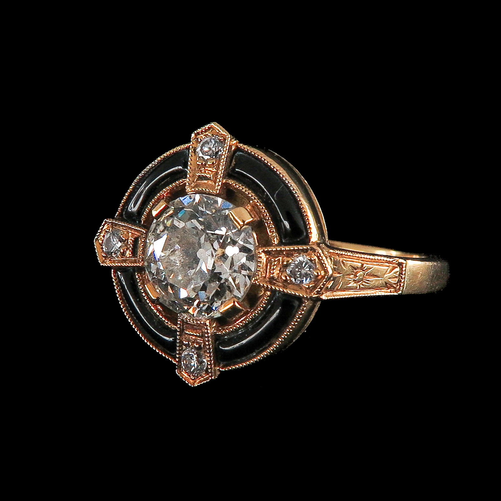 An 18KG Blanck Enamel Diamond Ring: 18 Krt. gold, set with a large antique diamond t of approx. 1.45 ct., surrounded by a black enameled broken rim, interrupted by 4 appliqués forming a cross, each with a diamond, ring size 17
