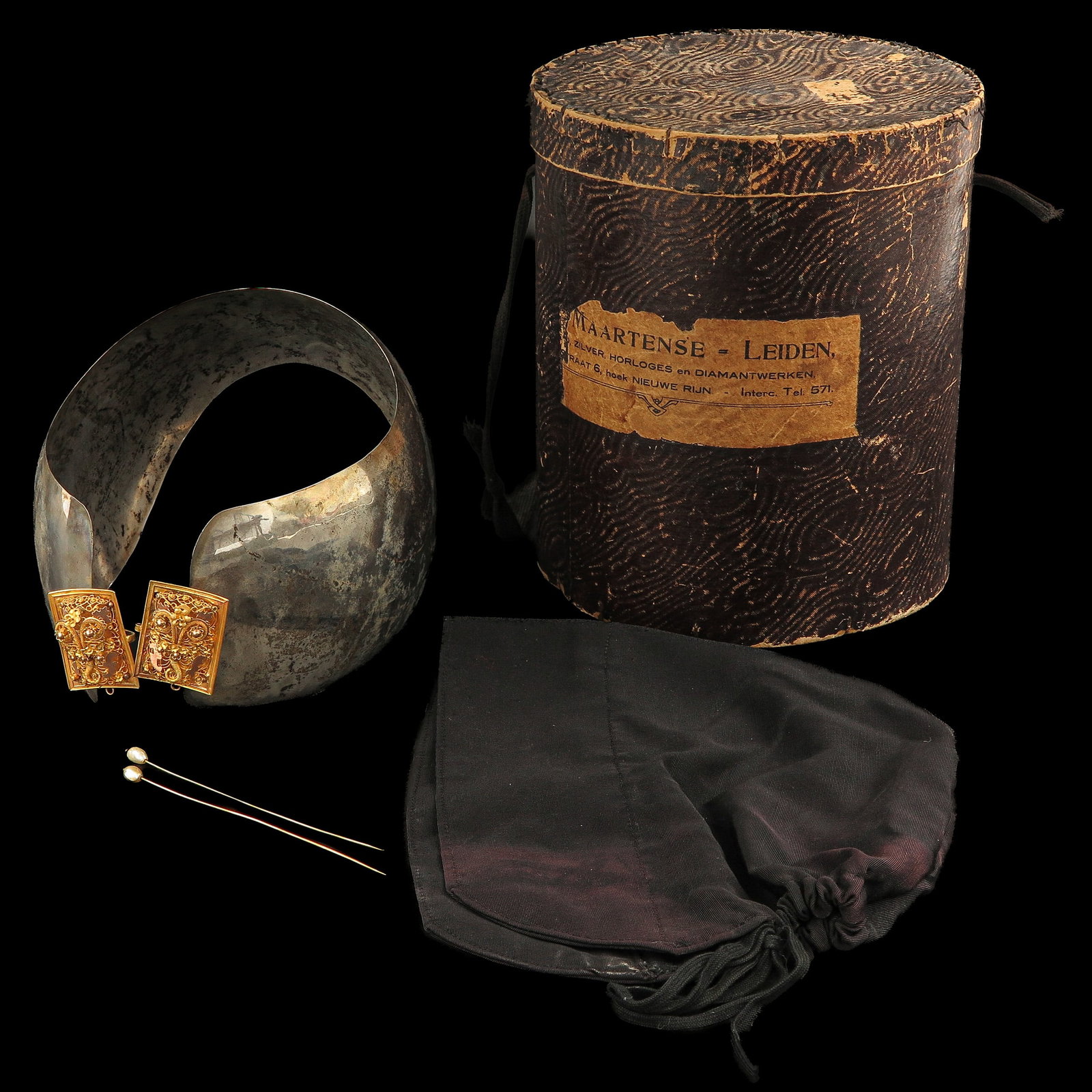 A Dutch Oorijzer: silver with 14 Krt. gold books, Katwijk, together with a pair of 14 Krt. gold hat pins with seed pearls, with box marked Maartense Leiden
