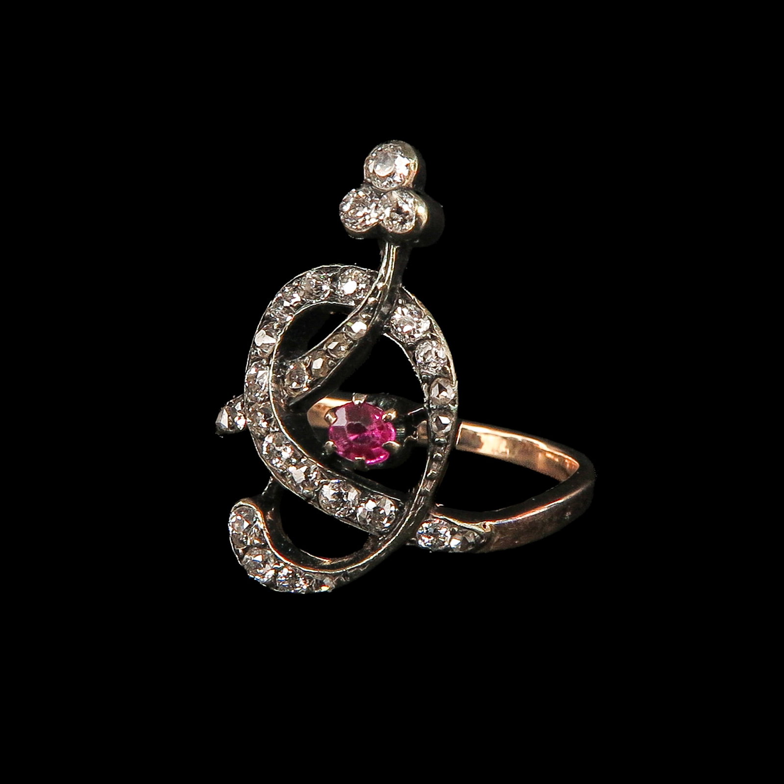 A Ladies Ruby and Diamond Ring: 14 Krt. gold with silver setting, Art Nouveau, set with 23 old-cut diamonds and a ruby ??of approx. 0.6 ct., ring size 17.5