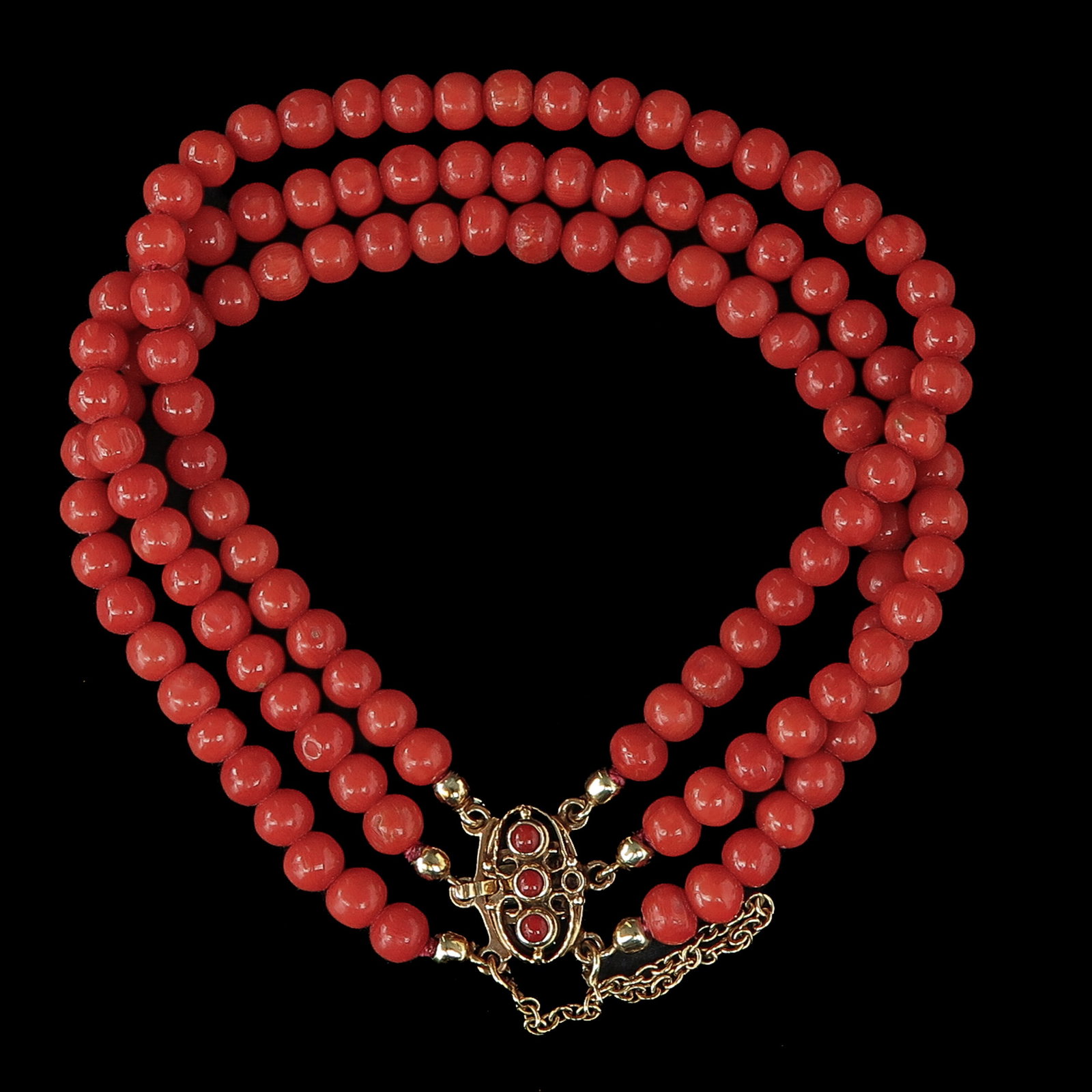 A Red Coral Bracelet: with 3 rows of blood coral, with 14 kt. gold clasp, length 15 cm