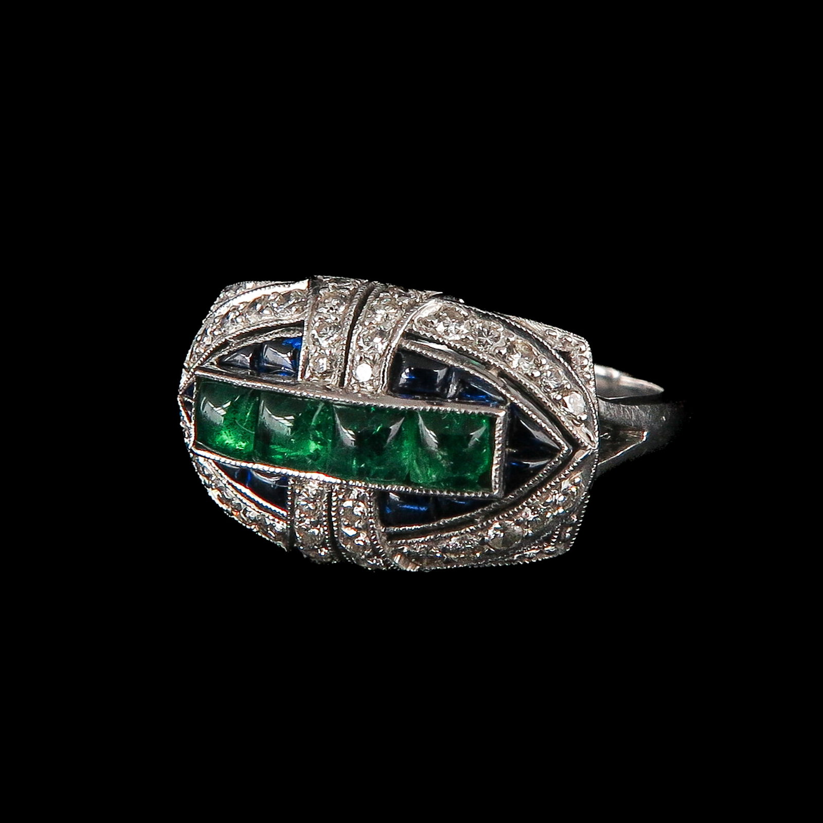 An Art Deco Ring: 18 Krt. gold, Art Deco, with 4 cabochon-cut emeralds in the central motif surrounded by sapphires and small diamonds, ring size 17.5