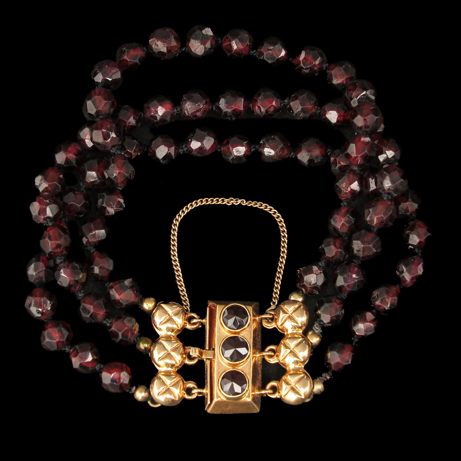 A Garnet Bracelet: with 3 rows of garnets, with 14 Krt. gold clasp, length 15 cm