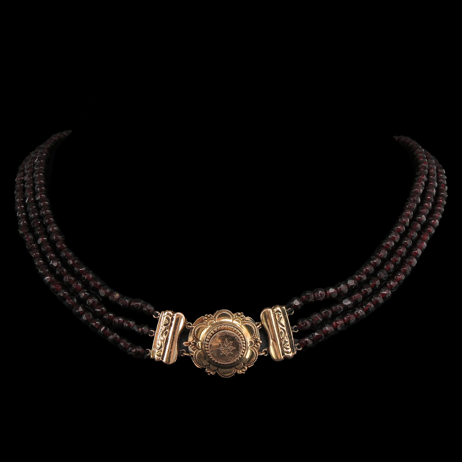A Garnet Necklace: with 3 rows of garnets, with 14 Krt. gold clasp, length 35 cm