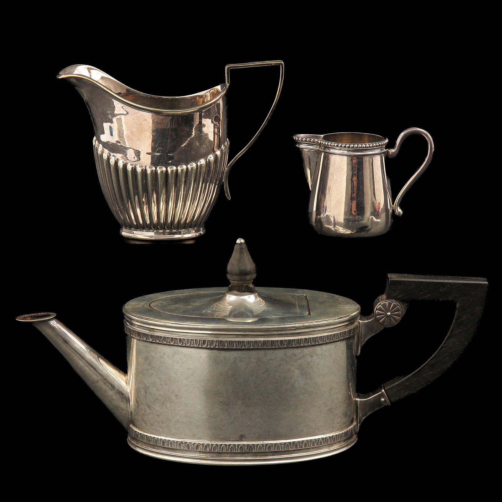 A Group of Silver: consisting of a teapot with wooden handle, a cream jug and a small jug, incl. silver