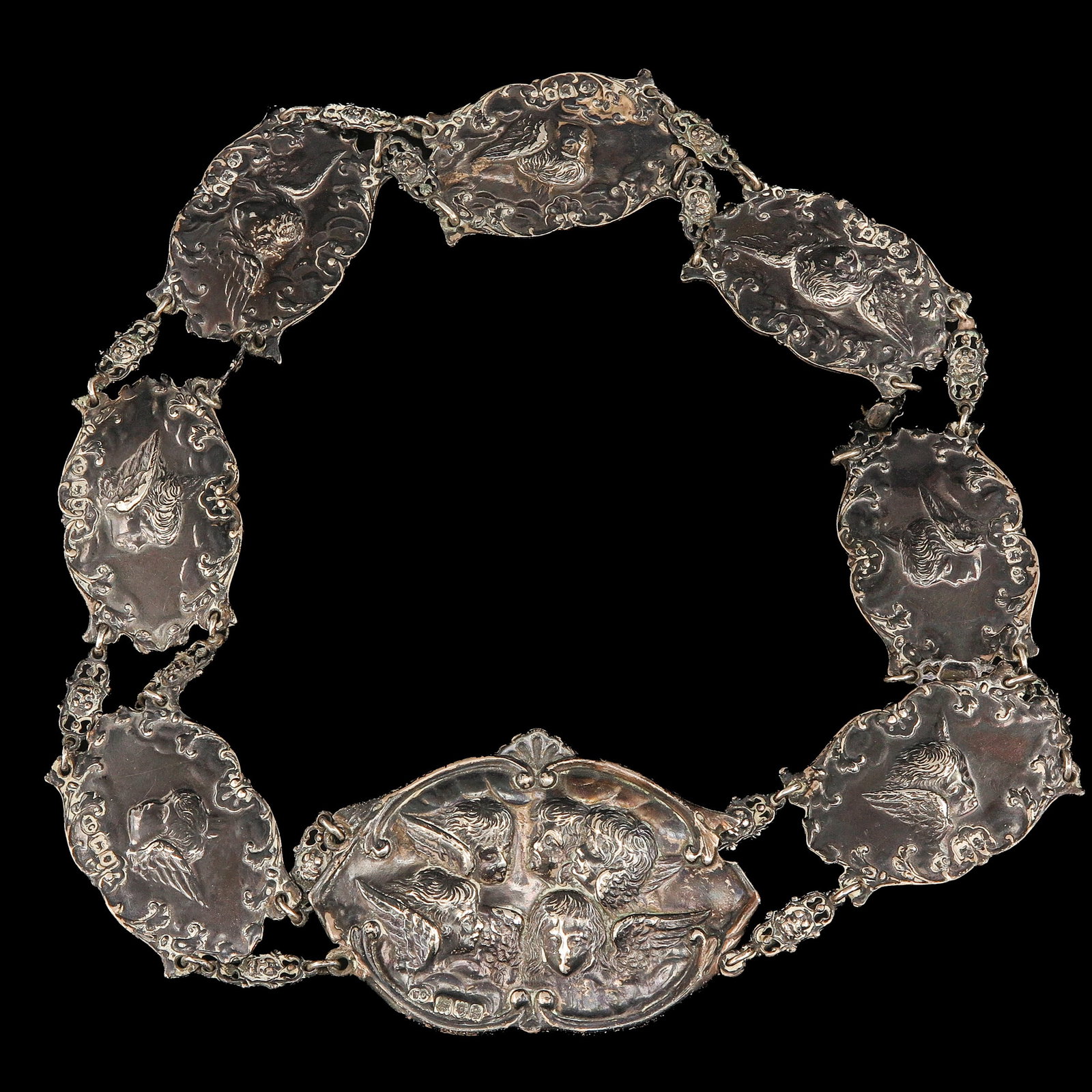 A Silver Nurse Belt: sterling silver, England, with repoussé decoration of putti and scrollwork, length 59 cm