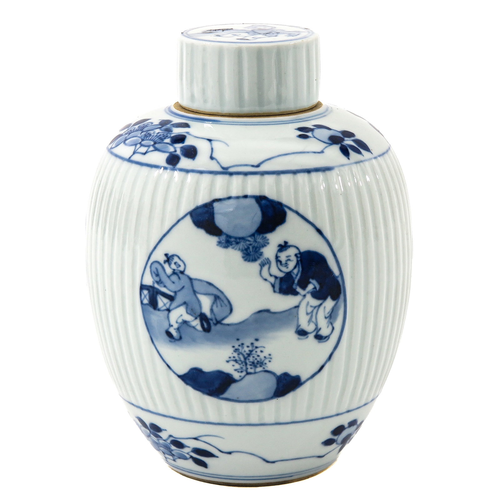 A Blue and White Tea Caddy: Ribbed body and decoration of boys playing in a garden scene, 17 cm tall.