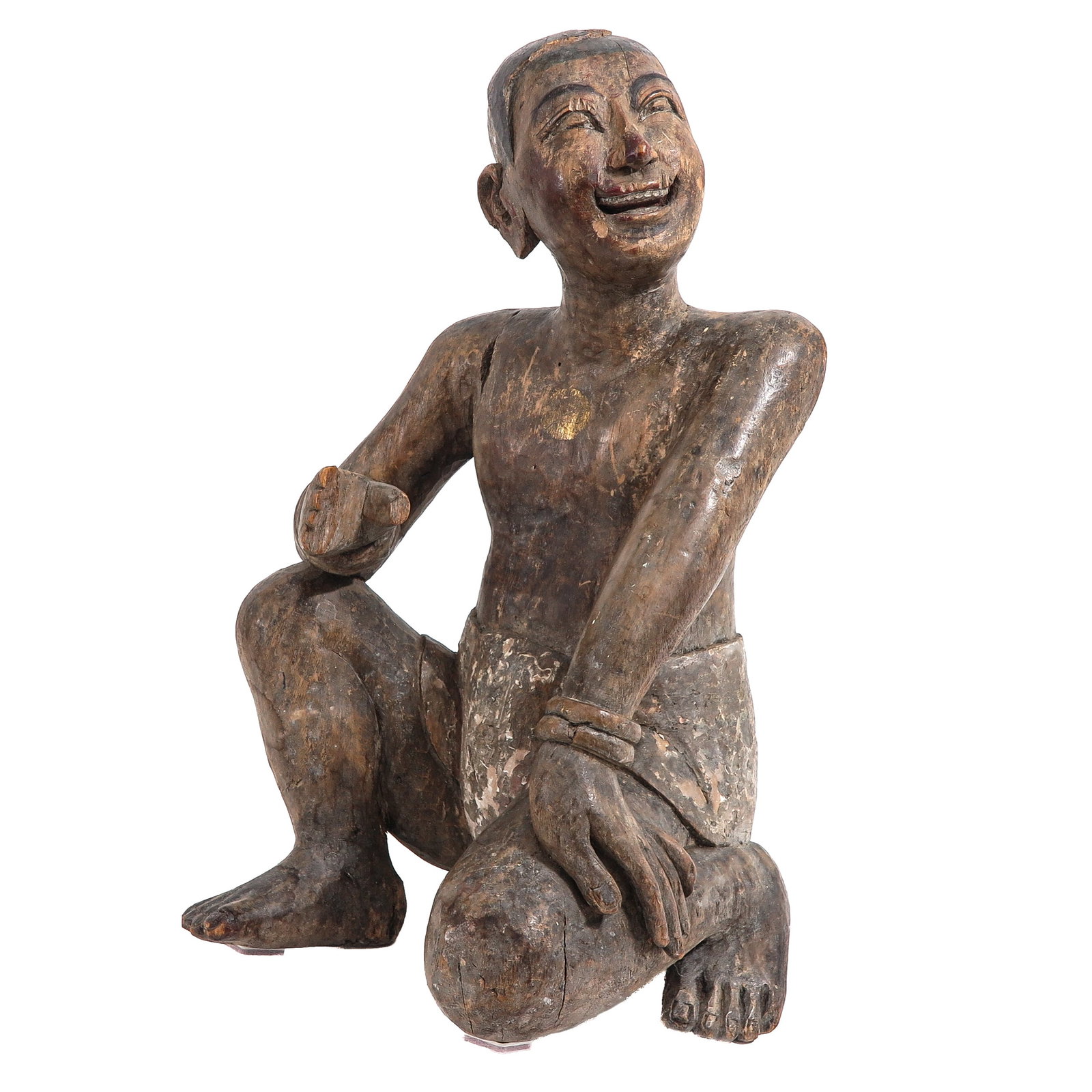 A Burmese Sculpture: Depicting a man in a seated pose, carved wood with remnants of original paint, 19th Century, pierced eyes and mouth, 50 cm tall.