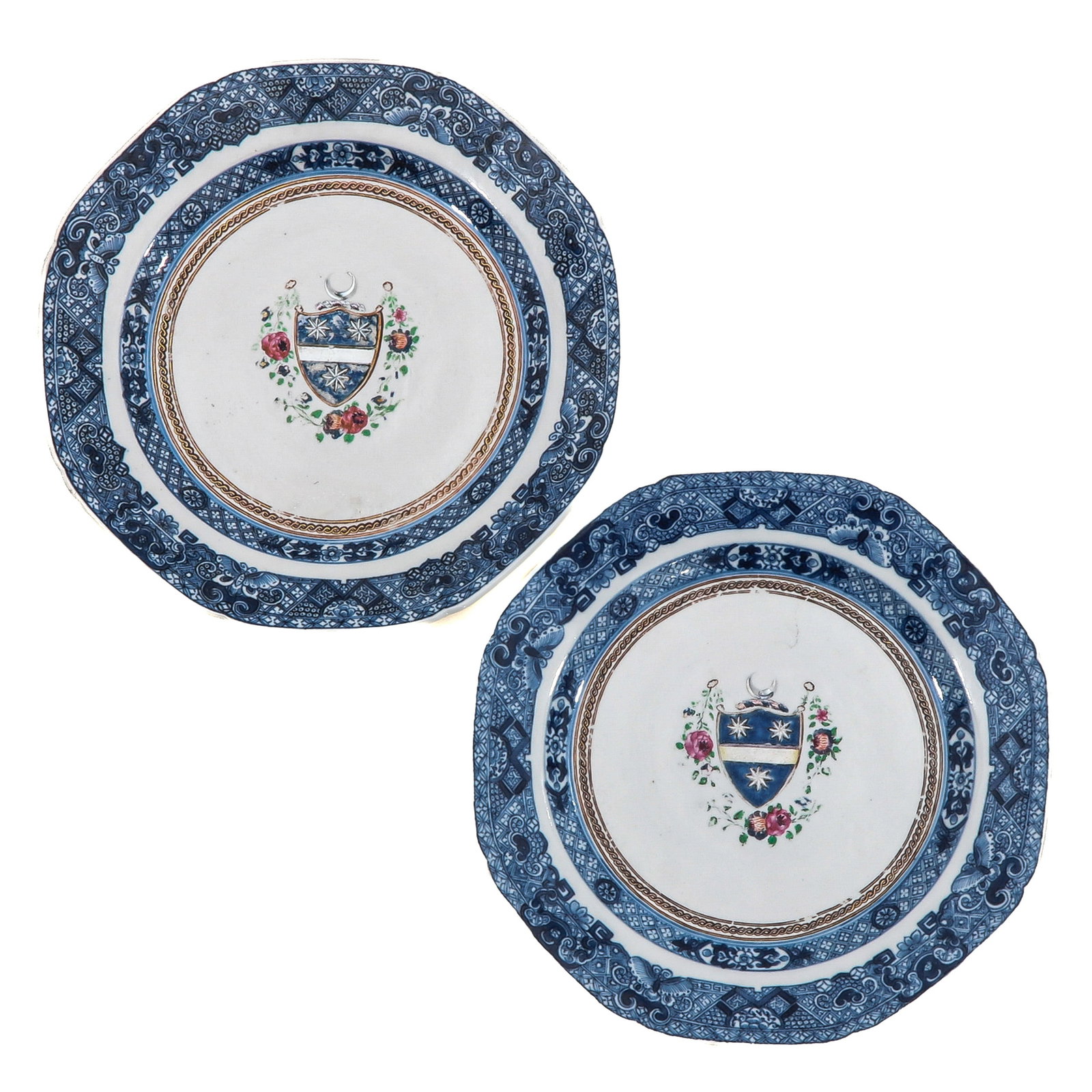 A Pair of Armorial Plates: Decorated in underglaze blue with a central coat of arms and floral accents, 24 cm in diameter, chip.