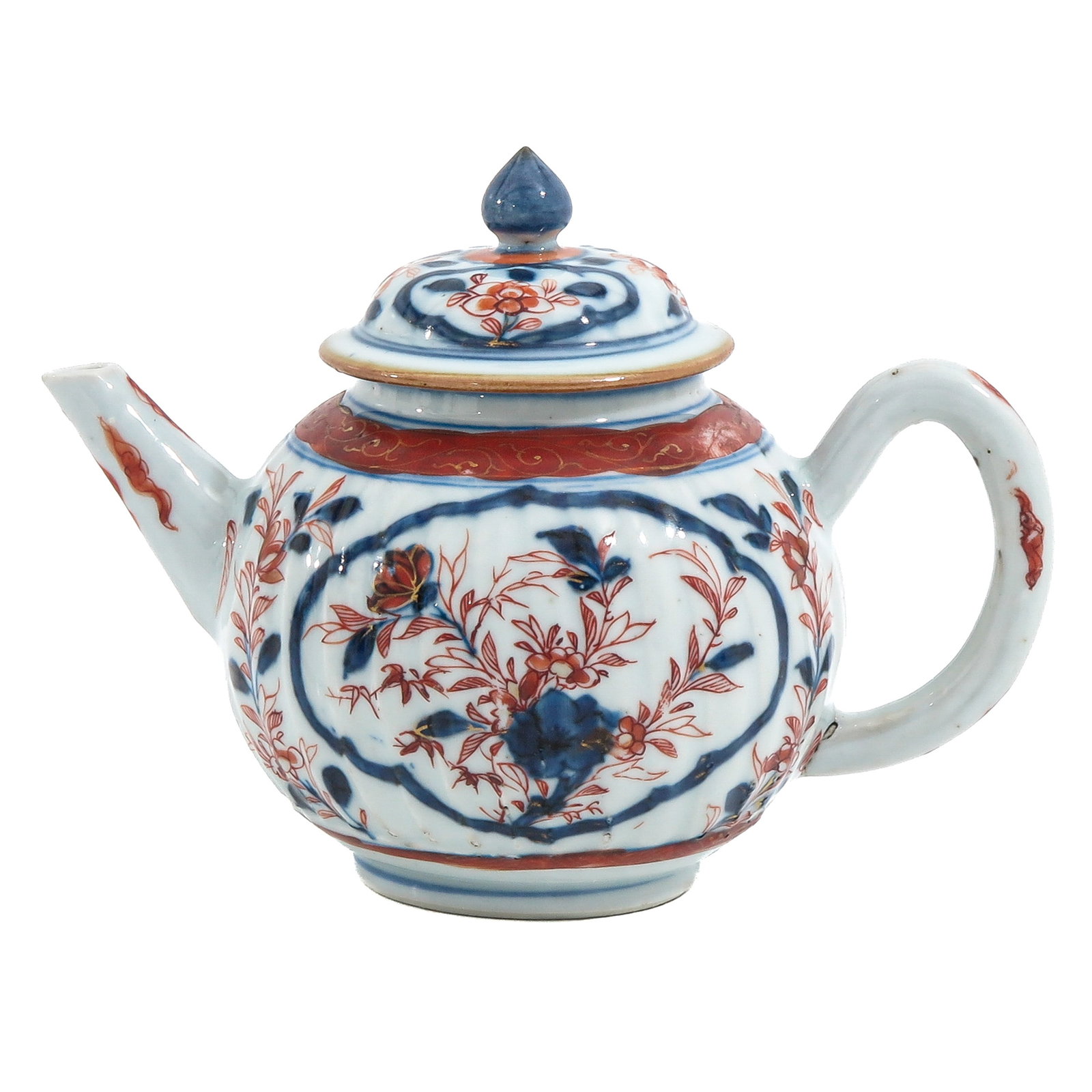 An Imari Teapot: Decorated with blue and iron-red floral sprays and scrolling foliage, 18th Century, 13 cm tall.