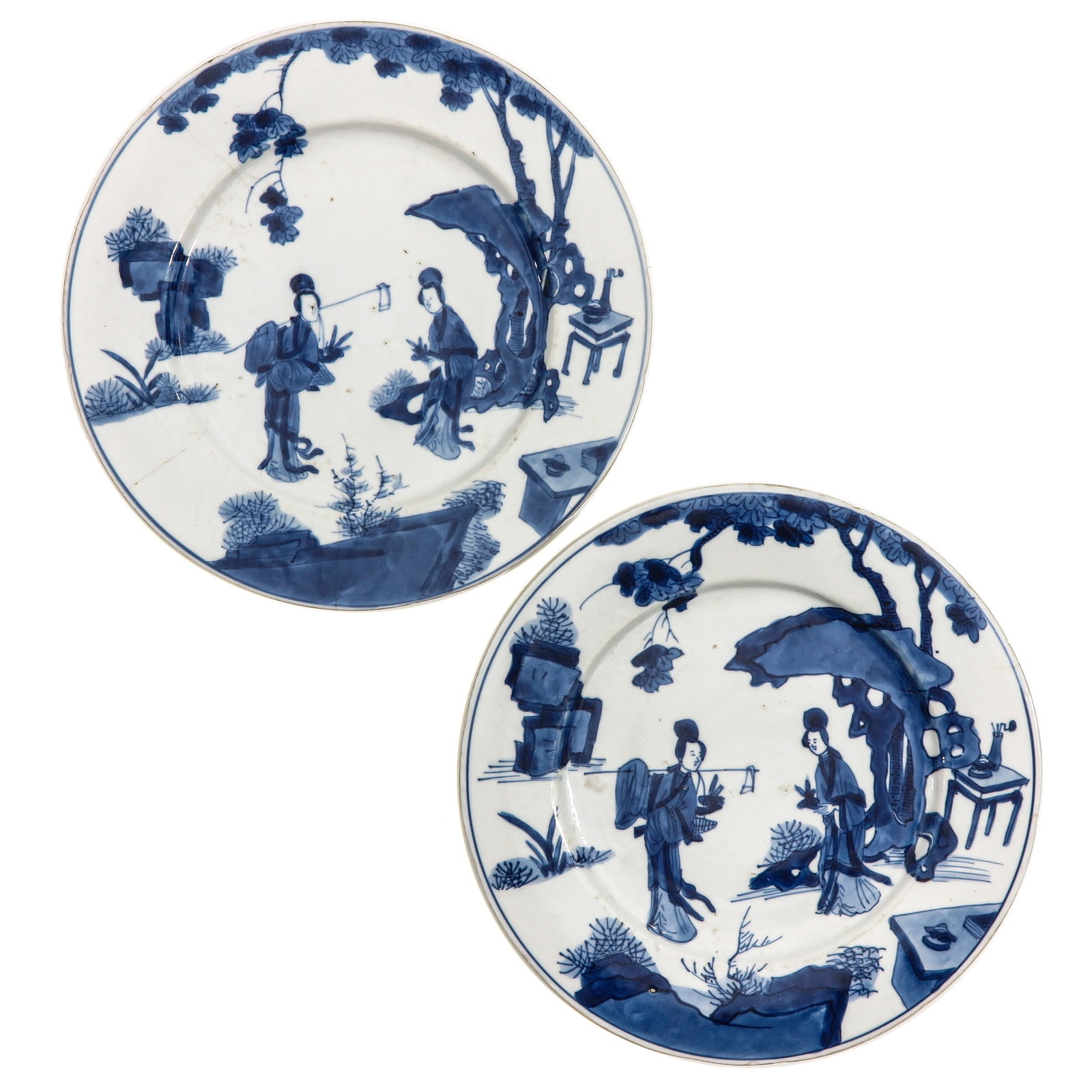 A Pair of Blue and White Plates: Decorated with Chinese ladies in a garden landscape, Kangxi Mark and Period, 21 cm in diameter, chip and hairline.