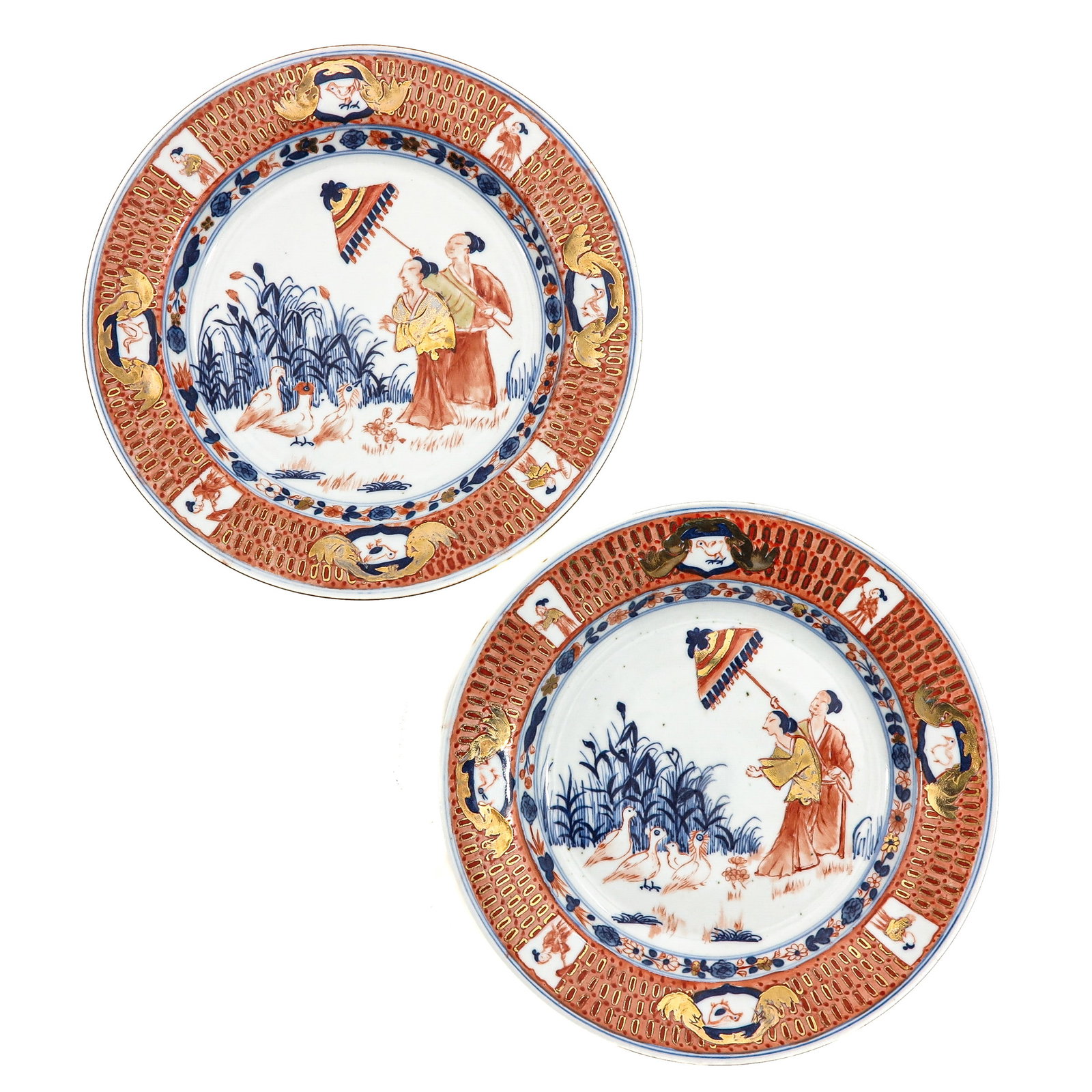 A Pair of Plates: Decorated with figures holding a parasol with ducks, in underglaze blue, iron-red and gilt enamels, 23 cm in diameter.