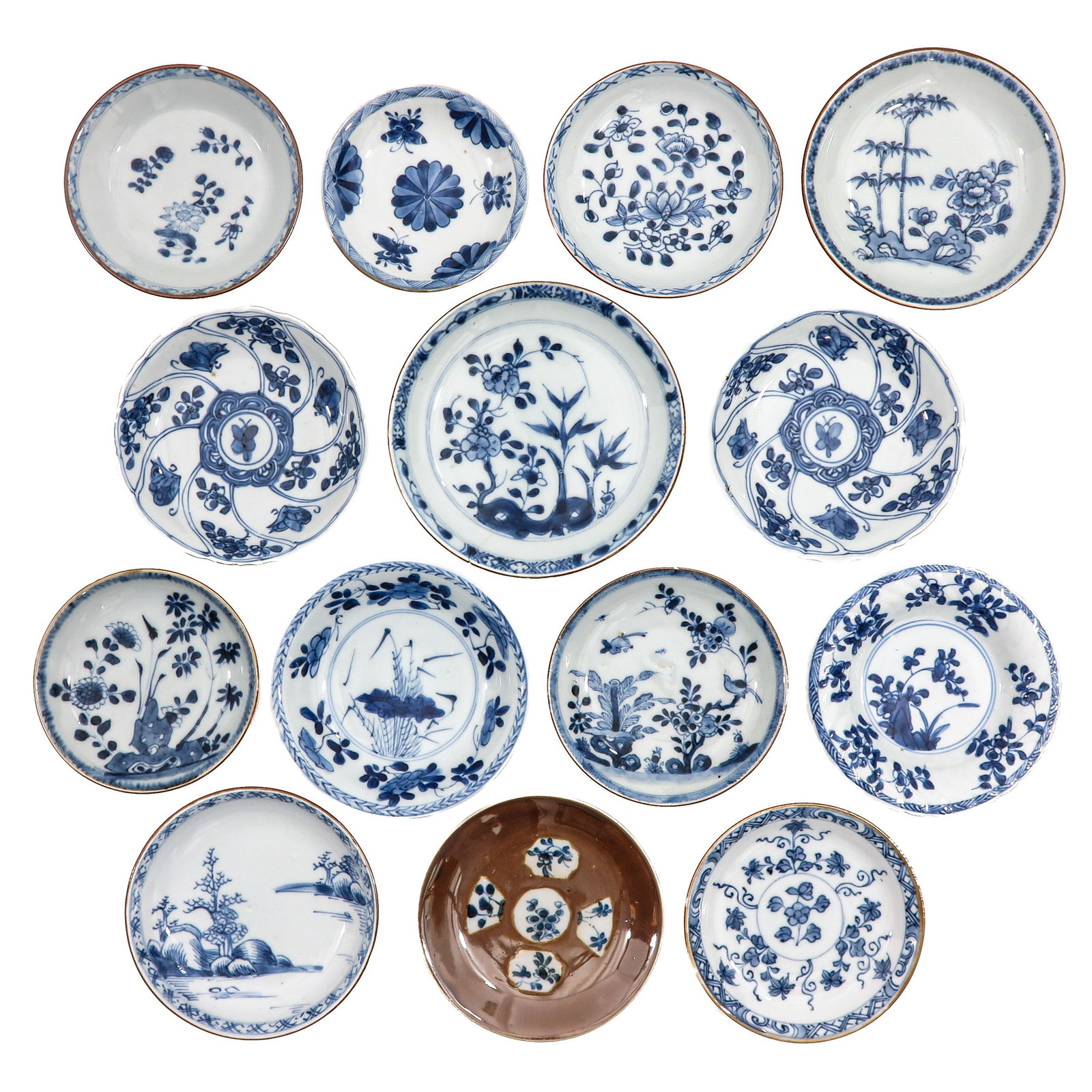 A Large Group of Saucers: Decorated in blue and white motifs of flowers, bamboo, and landscapes, including 18th Century, largest saucer is 13 cm in diameter, in diverse conditions.